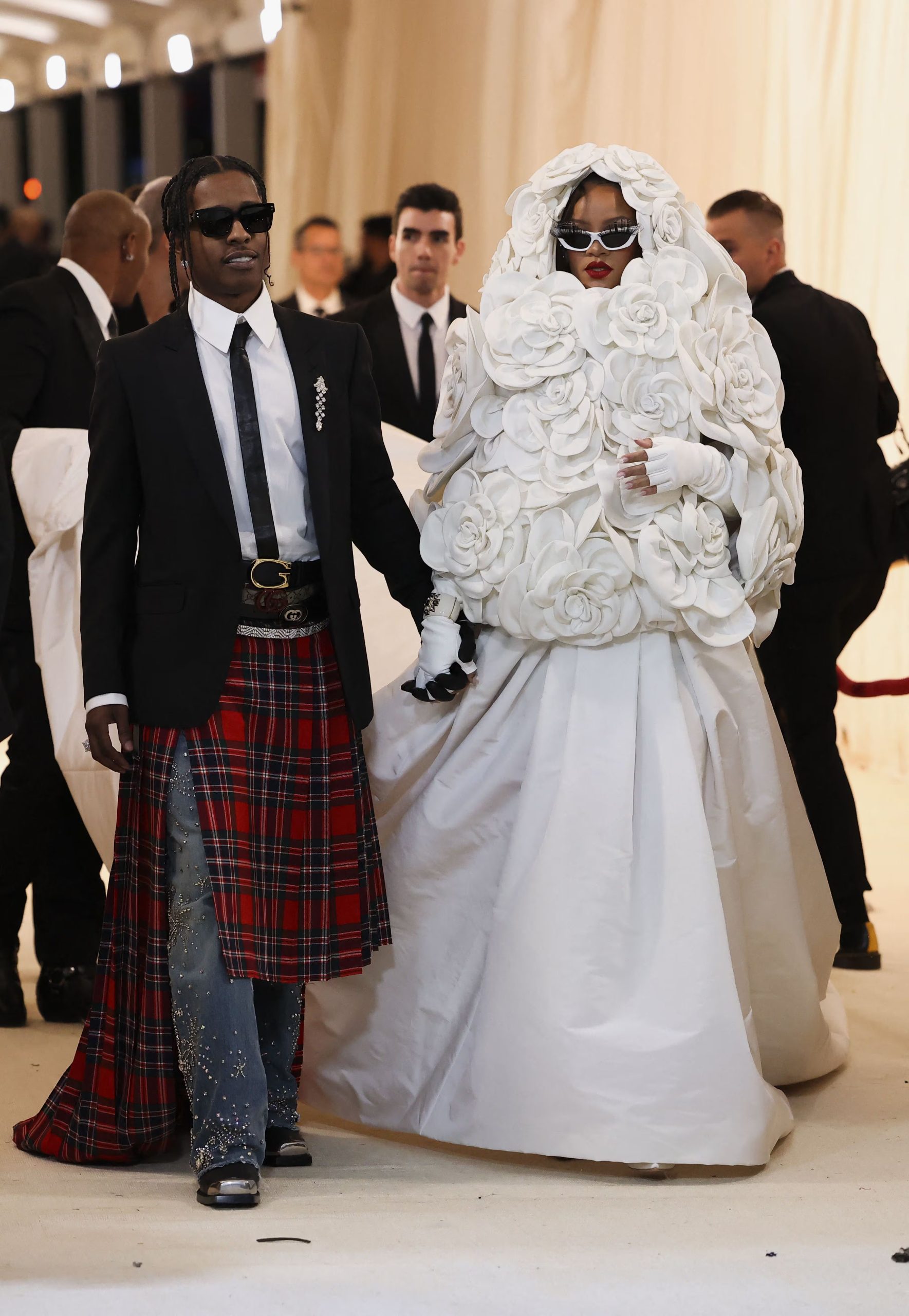 Rihanna convierte un abrigo floral voluminoso en alta costura callejera, A$AP Rocky mezcla traje negro con falda escocesa roja y detalles punk (REUTERS/Andrew Kelly)