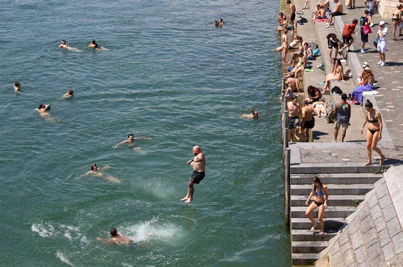 Basilea integra el río Rin a la vida diaria y mantiene una tradición de baño urbano que en verano incluye traslados al trabajo por la corriente (REUTERS/Bernadett Szabo)