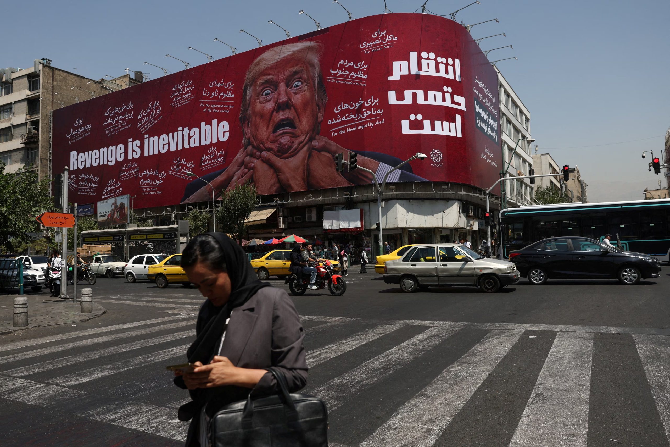 Una mujer camina cerca de una valla publicitaria con la imagen del presidente estadounidense Donald Trump en un edificio de Teherán, Irán. 27 julio de 2026 (Majid Asgaripour/WANA vía Reuters)