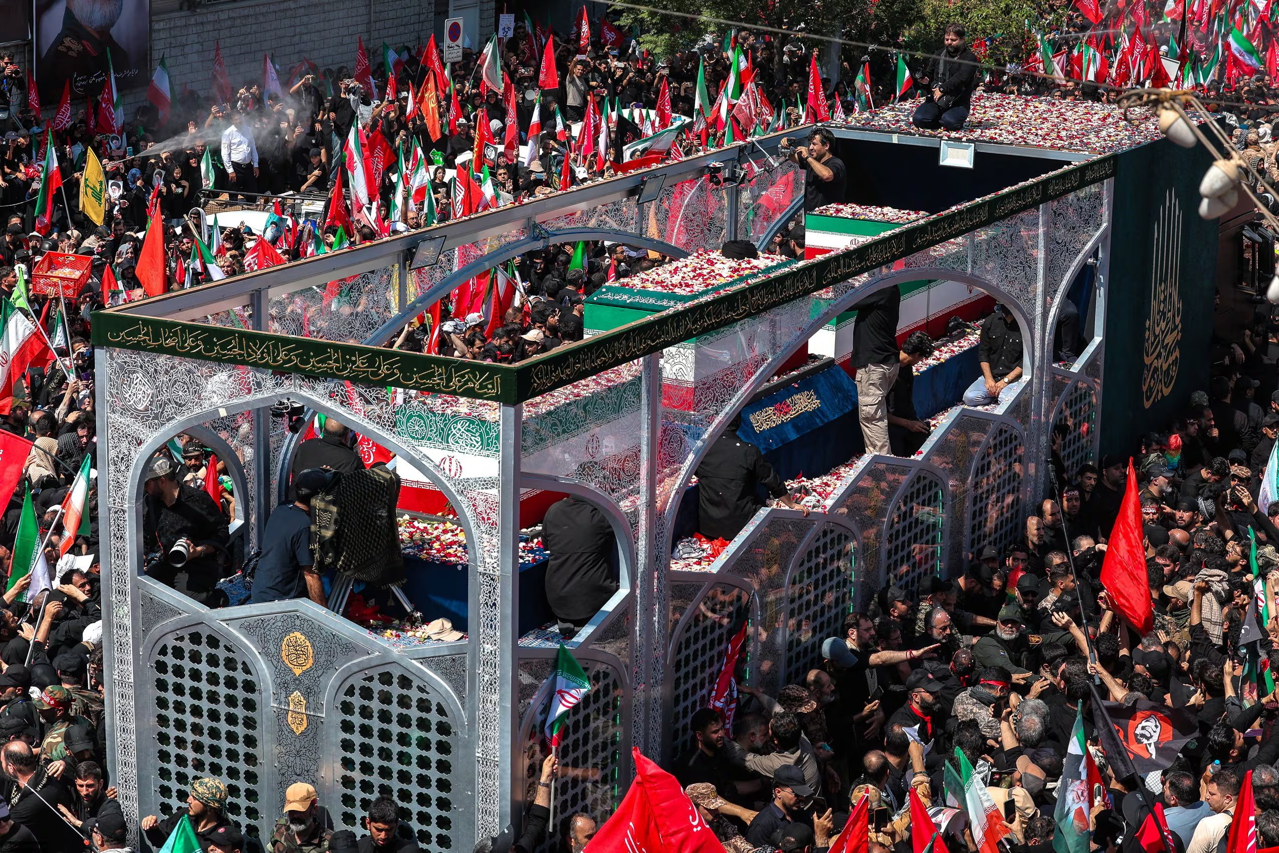 Personas participan en la procesión funeraria del ayatolá Ali Khamenei mientras los féretros del líder iraní y miembros de su familia son trasladados en Teherán