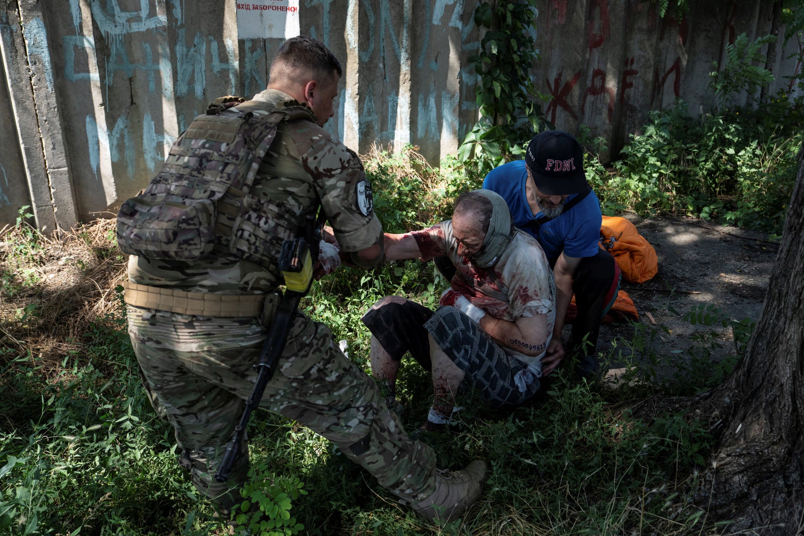 Un militar de la 93ª Brigada Mecanizada ucraniana asiste a un residente herido tras un ataque ruso con drones en la ciudad fronteriza de Druzhkivka, en la región de Donetsk. (Iryna Rybakova/REUTERS)