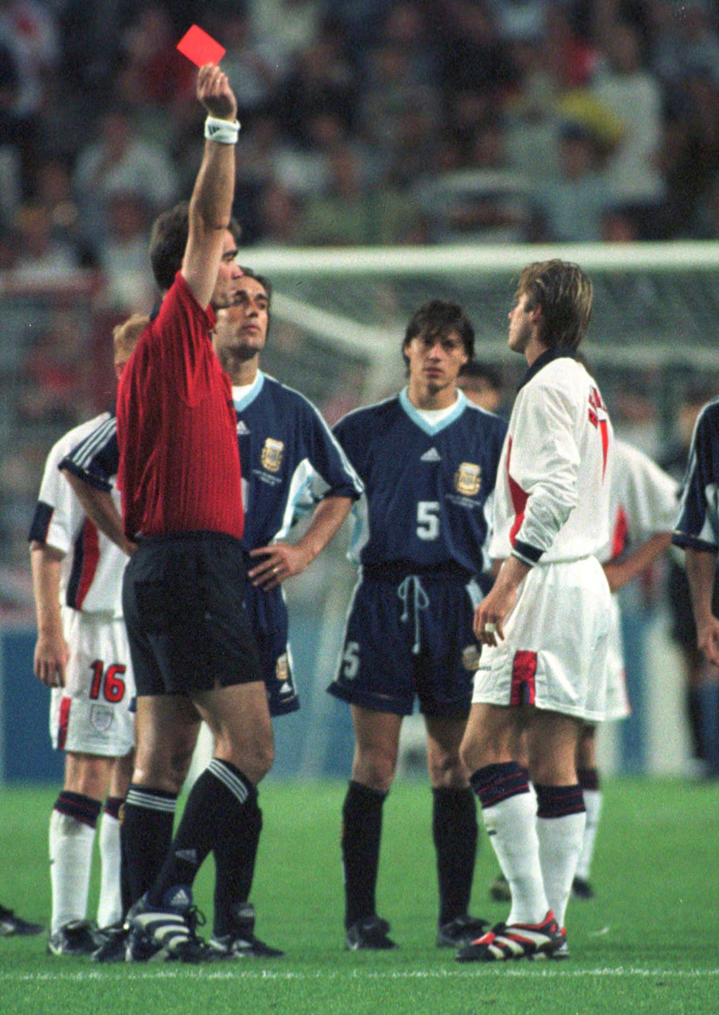 El jugador inglés David Beckham recibe una tarjeta roja del árbitro danés Kim Milton Nielsen por patear al jugador argentino Diego Simeone, durante los octavos de final del Mundial entre Inglaterra y Argentina, en Saint Etienne, Francia, el 30 de junio de 1998 (Foto AP/Denis Doyle, archivo)