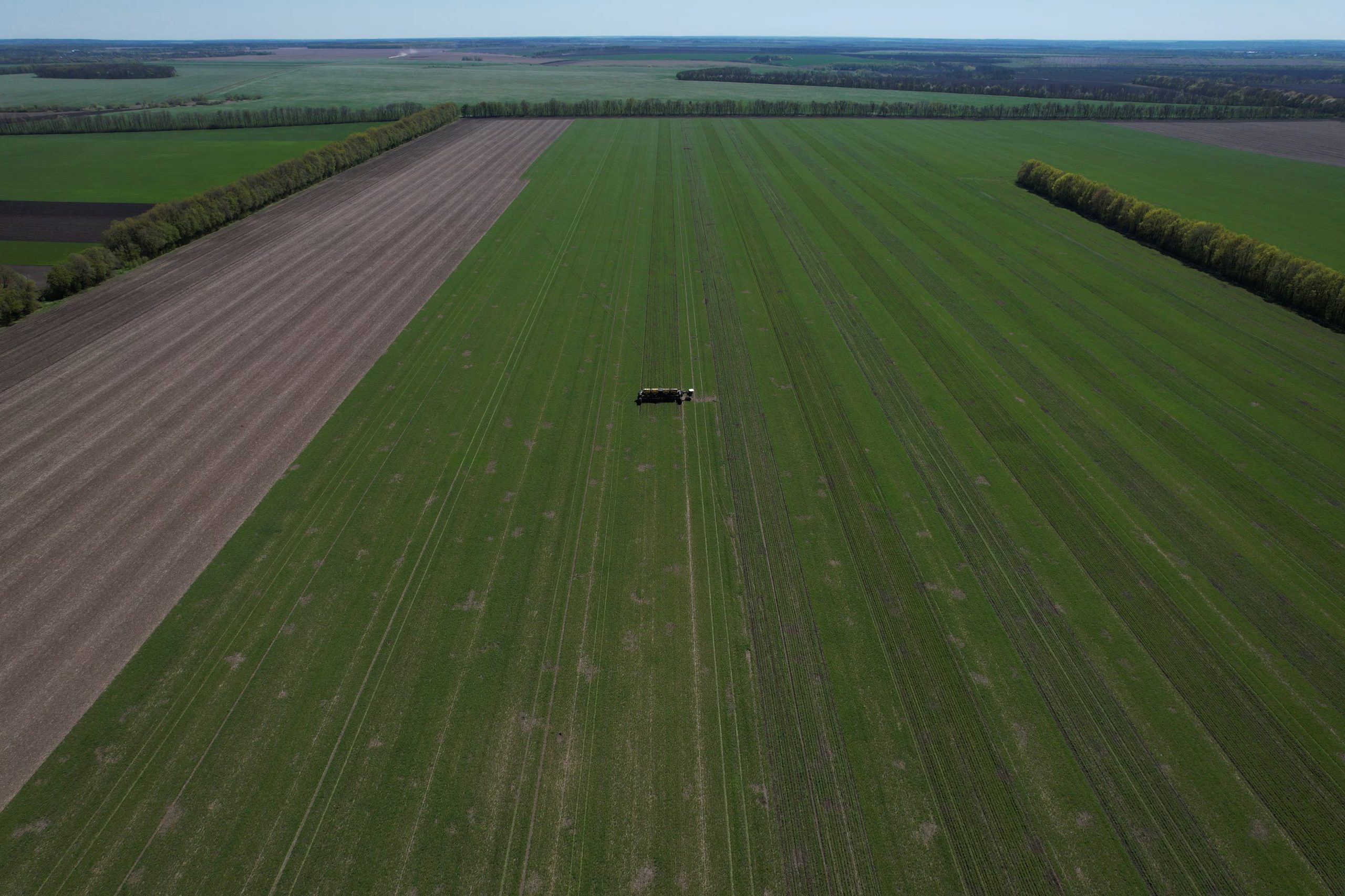 Un trabajador agrícola maneja una sembradora en un campo cercano al pueblo de Kyshchentsi, en plena invasión rusa de Ucrania, en la región de Cherkasy, Ucrania, el 1 de mayo de 2023. (REUTERS/Valentyn Ogirenko/Archivo)