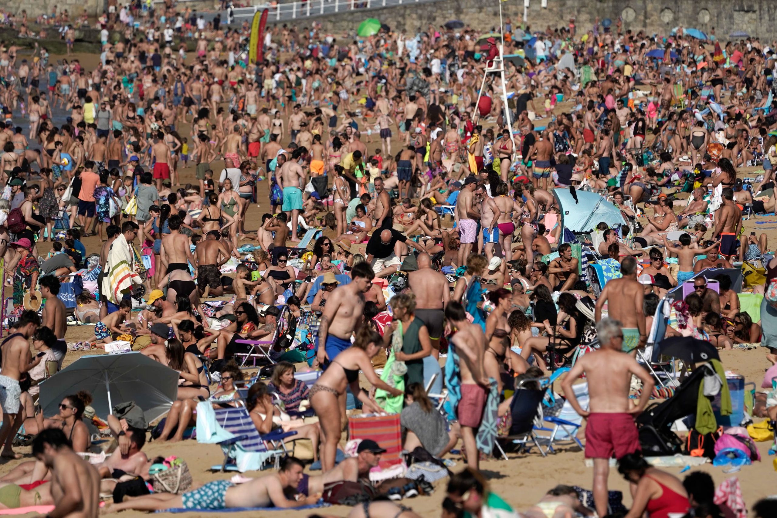 Bañistas y paseantes en la playa de San Lorenzo de Gijón a 16 de julio de 2025. (EFE/Paco Paredes)