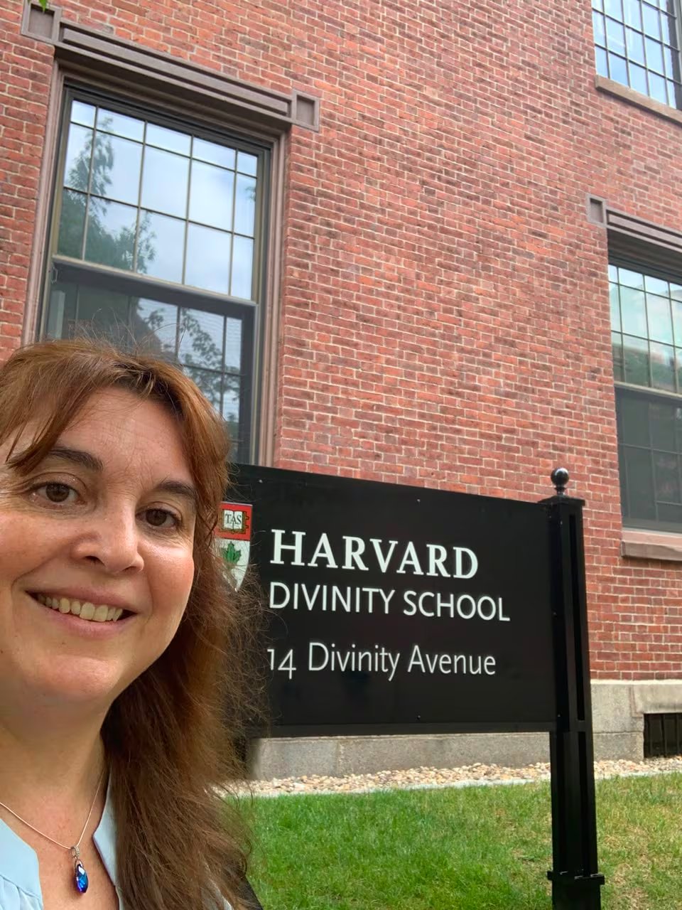 Tamara Rubilar sonríe frente al letrero de la Harvard Divinity School, donde realizó una presentación recientemente