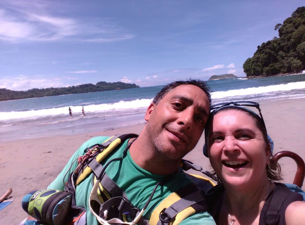 Tamara Rubilar y su marido Francisco sonríen en un selfie con la playa, el mar y dos islas de fondo. ((Gentileza Tamara Rubilar))