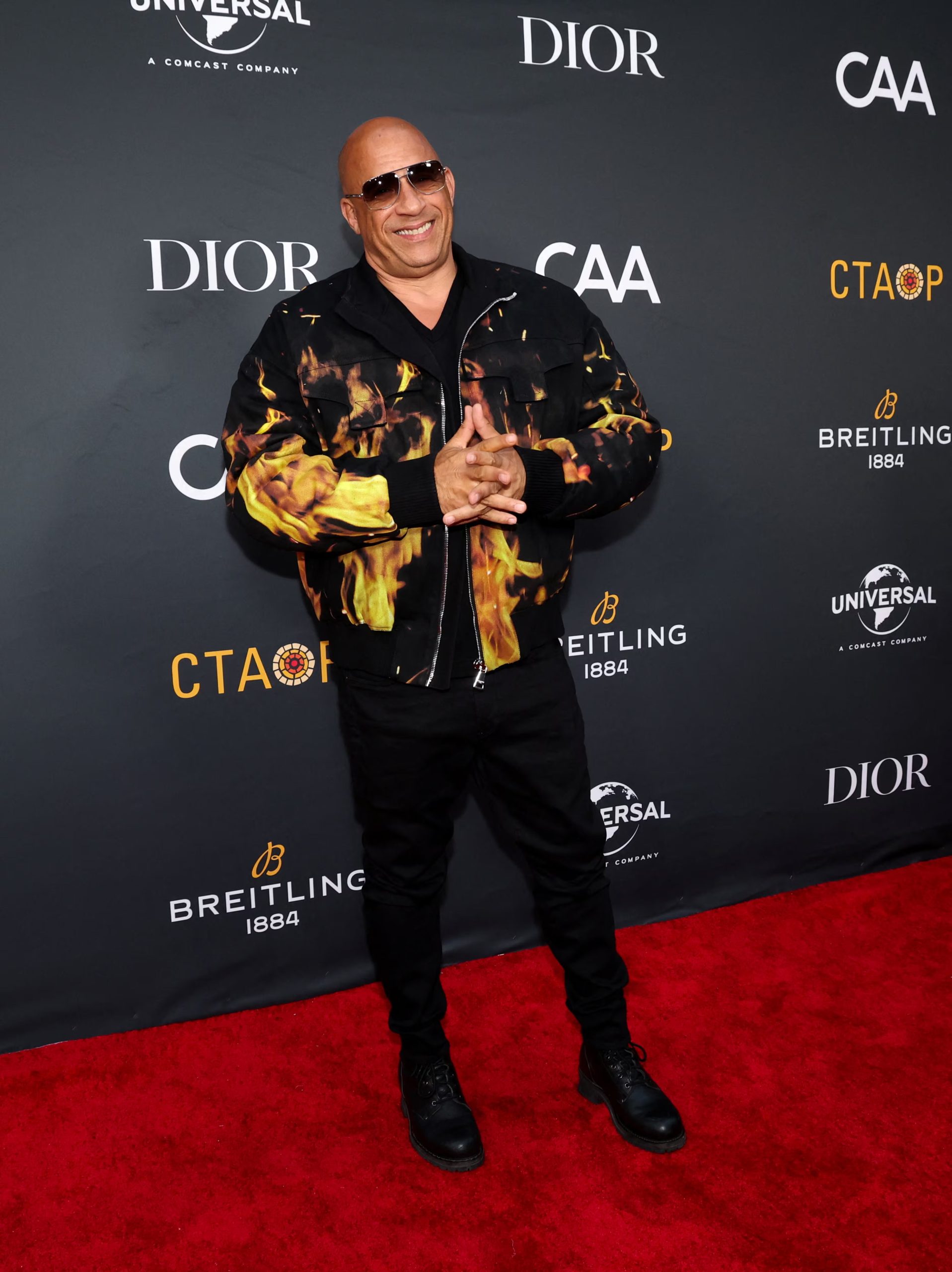 Chaqueta bomber con estampado de llamas en un evento de la organización Charlize Theron Africa Outreach Project (CTAOP) en Los Ángeles, California