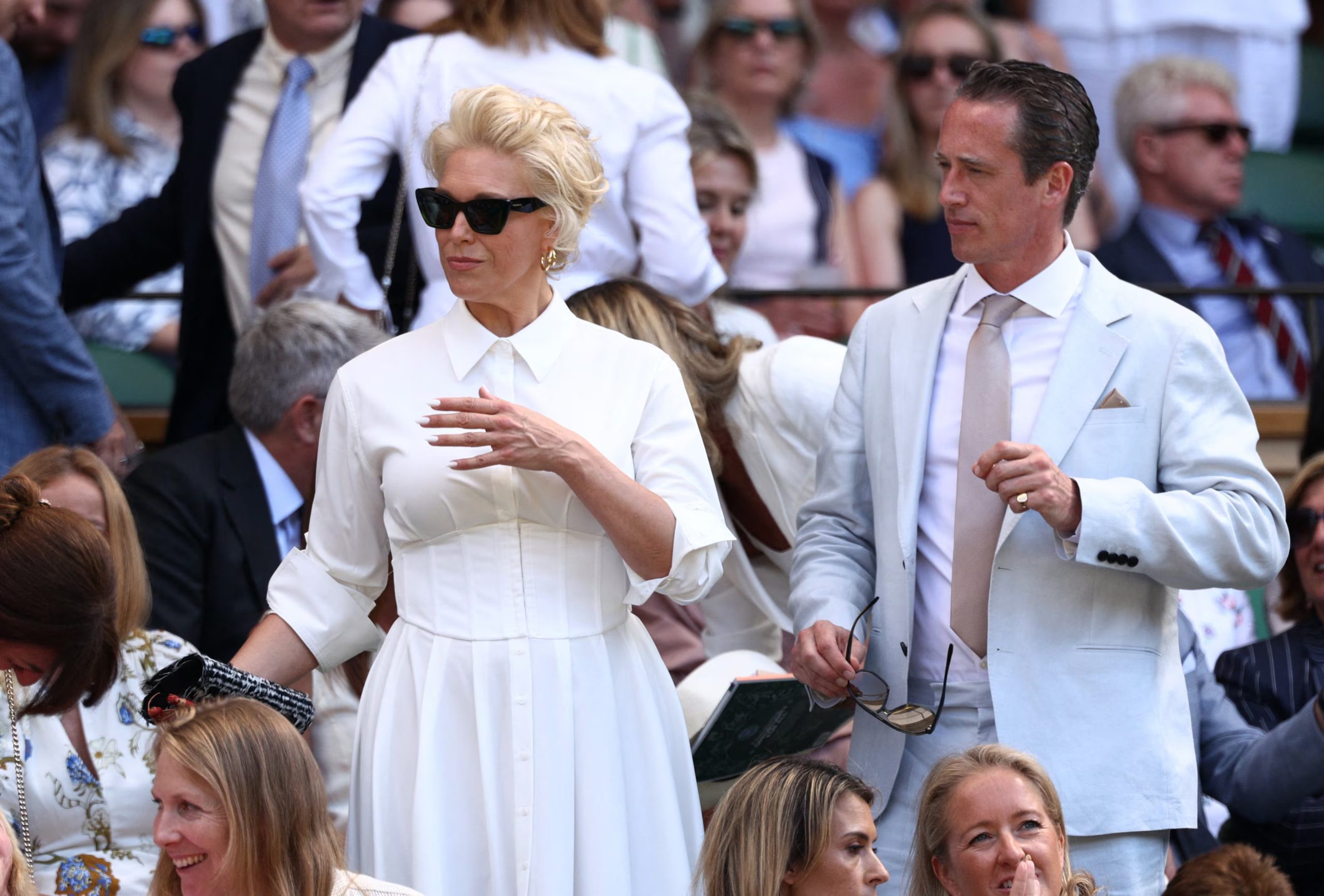 Hannah Waddingham y Nick Beresford suman blanco y celeste con accesorios dorados, pañuelo al bolsillo y gafas de sol