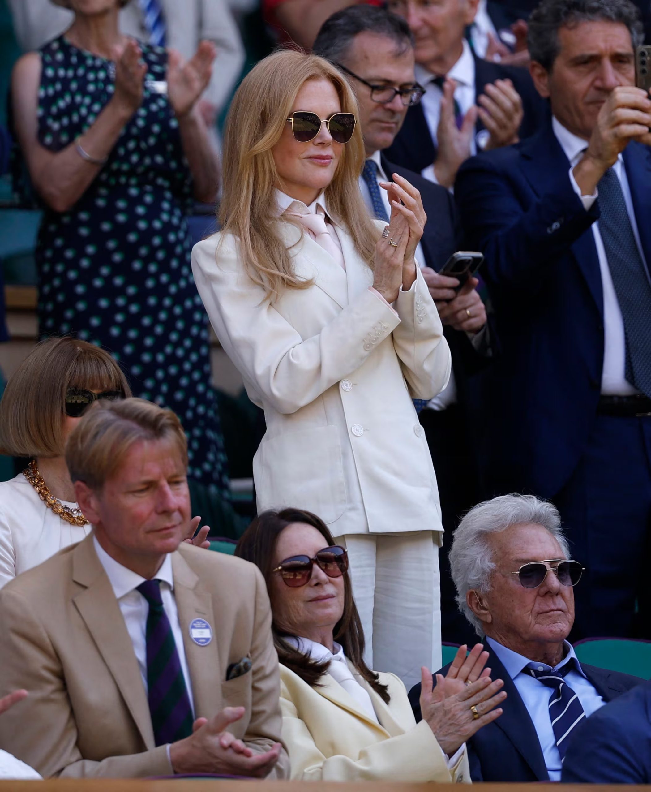 Nicole Kidman apuesta por un traje marfil con corbata clara y sombrero beige, con ondas sueltas y maquillaje tenue