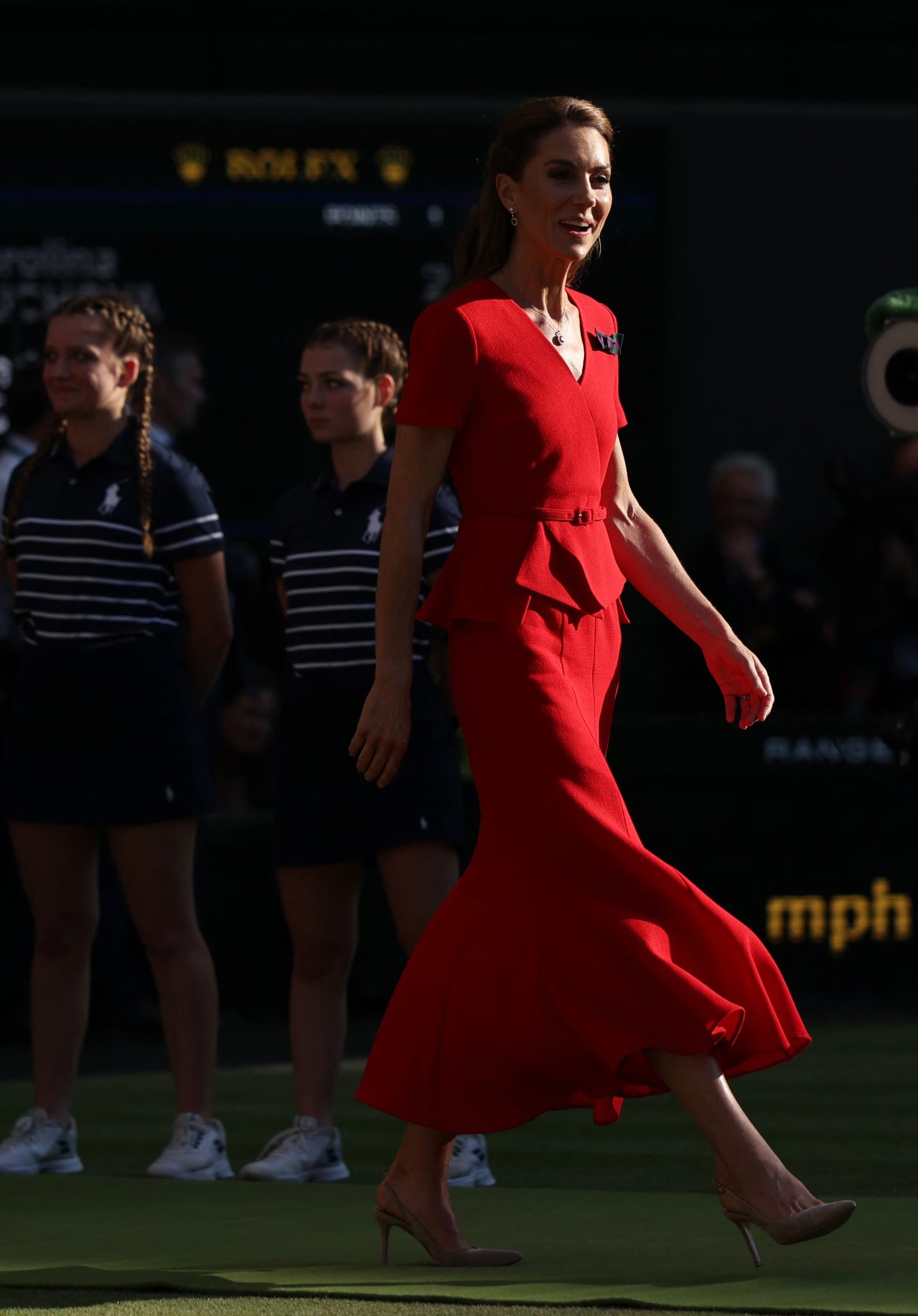 Kate Middleton opta por un vestido rojo con cinturón y falda amplia, con tacones nude y peinado parcialmente recogido