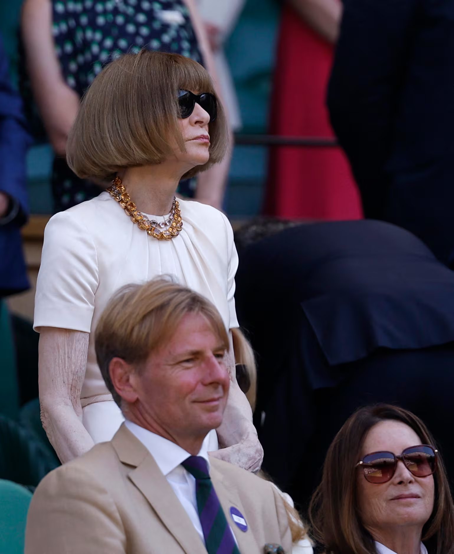 Anna Wintour cambia a blanco minimalista con collar dorado y gafas oscuras, manteniendo su estética reconocible