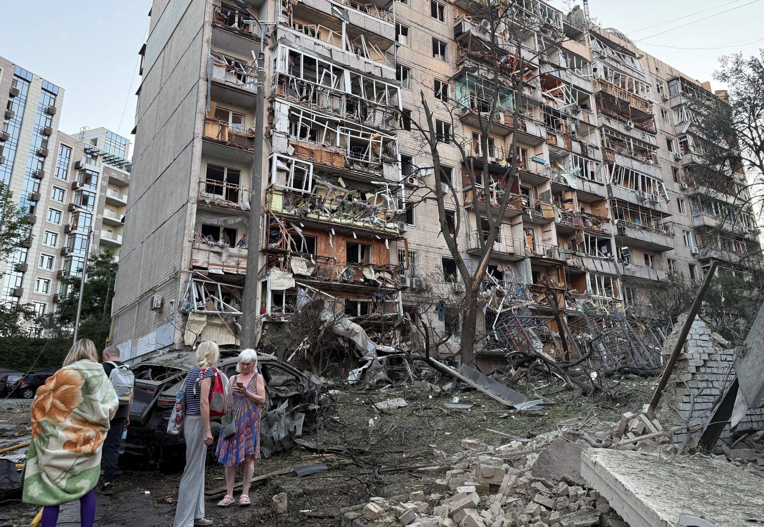 Varios residentes se encuentran junto a un bloque de apartamentos dañado durante un ataque con misiles y drones rusos, en el marco de la invasión de Ucrania por parte de Rusia, en Kiev, Ucrania, el 2 de julio de 2026 (REUTERS)