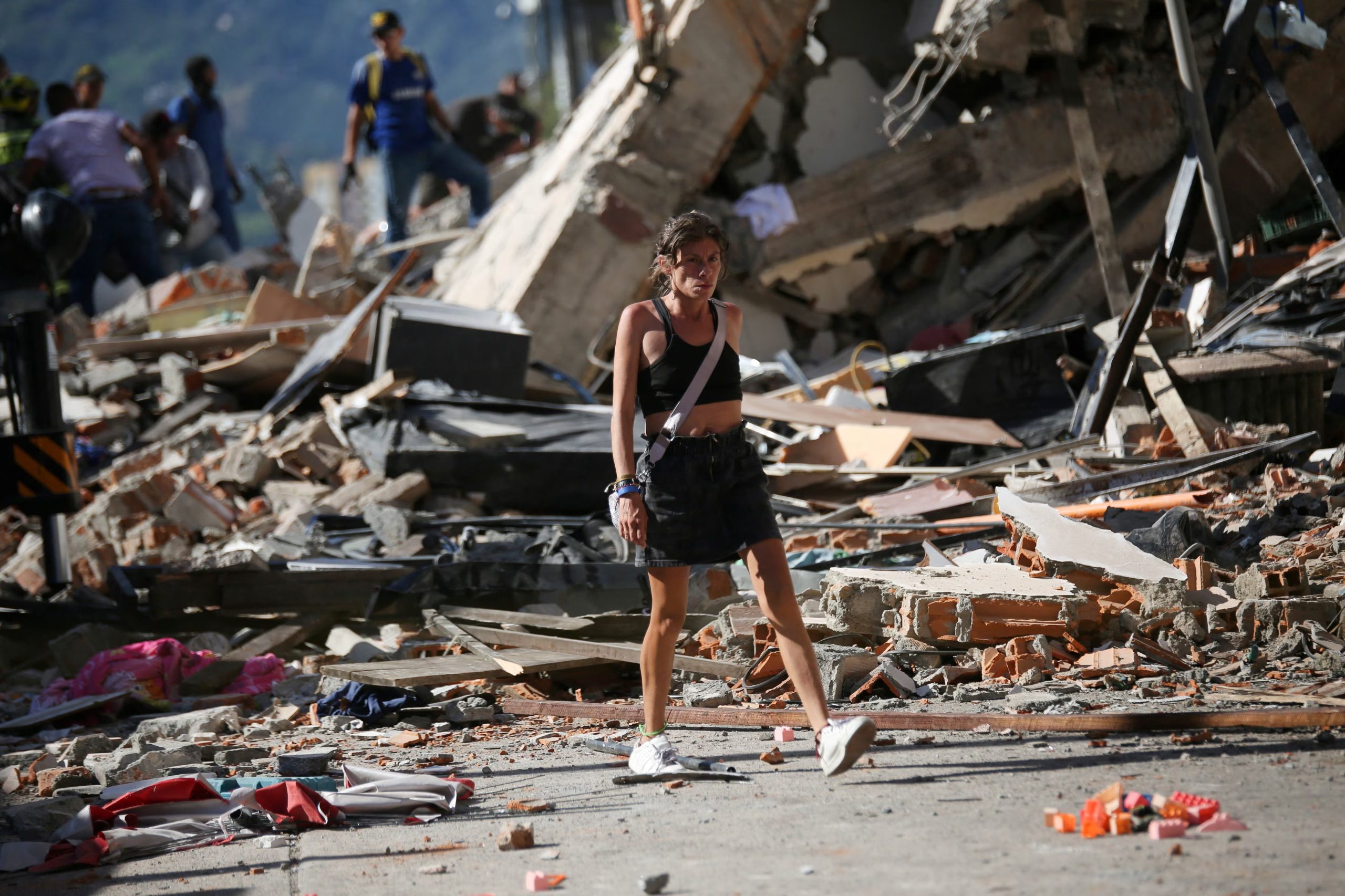 Una mujer pasa junto a los escombros de unos edificios derrumbados tras un terremoto, en Pereira (Colombia), el 10 de agosto de 2026. REUTERS/Juan David Duque