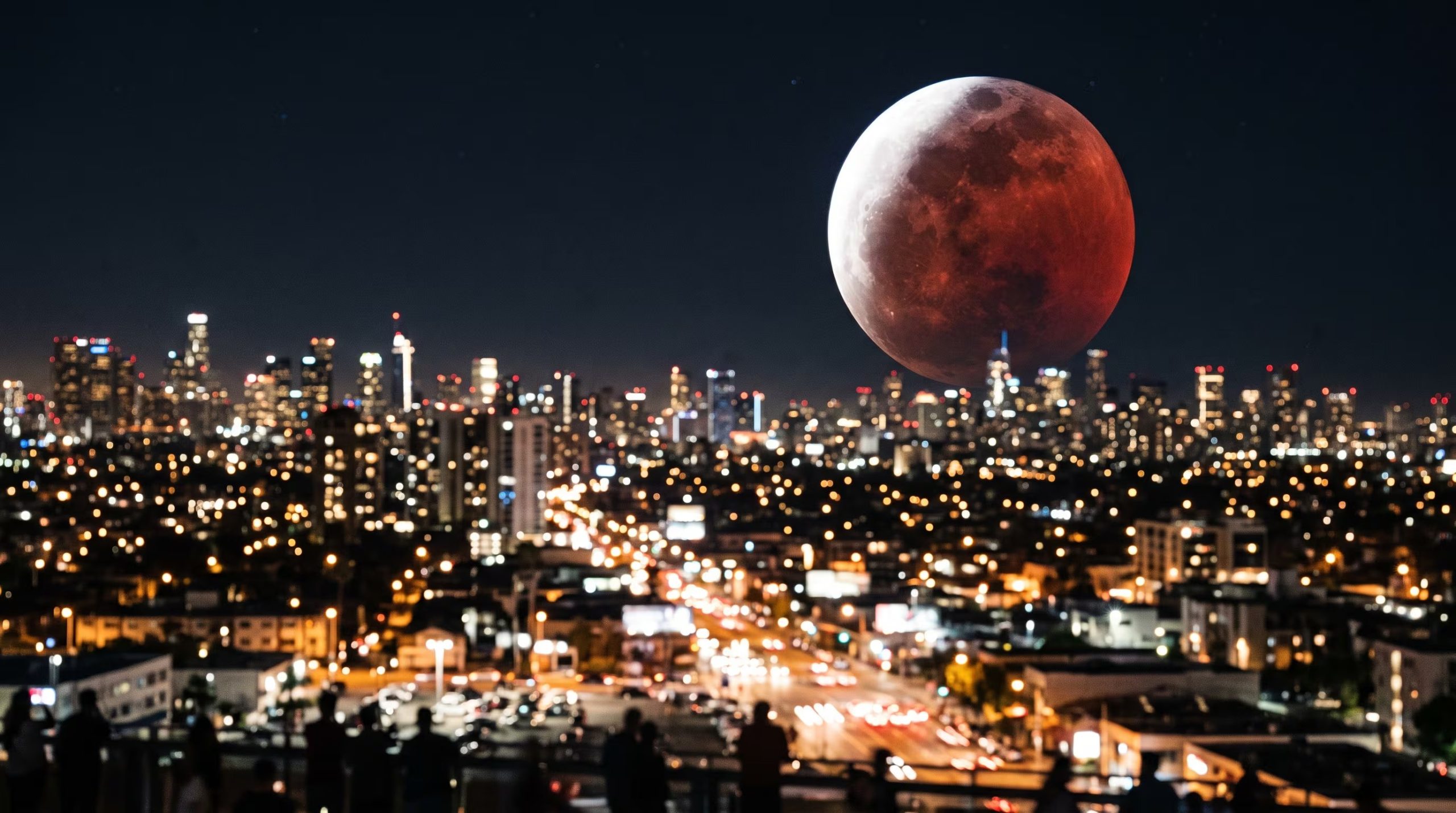 Un eclipse parcial de Luna se proyecta sobre el horizonte nocturno de una ciudad iluminada. (Imagen Ilustrativa Infobae)
