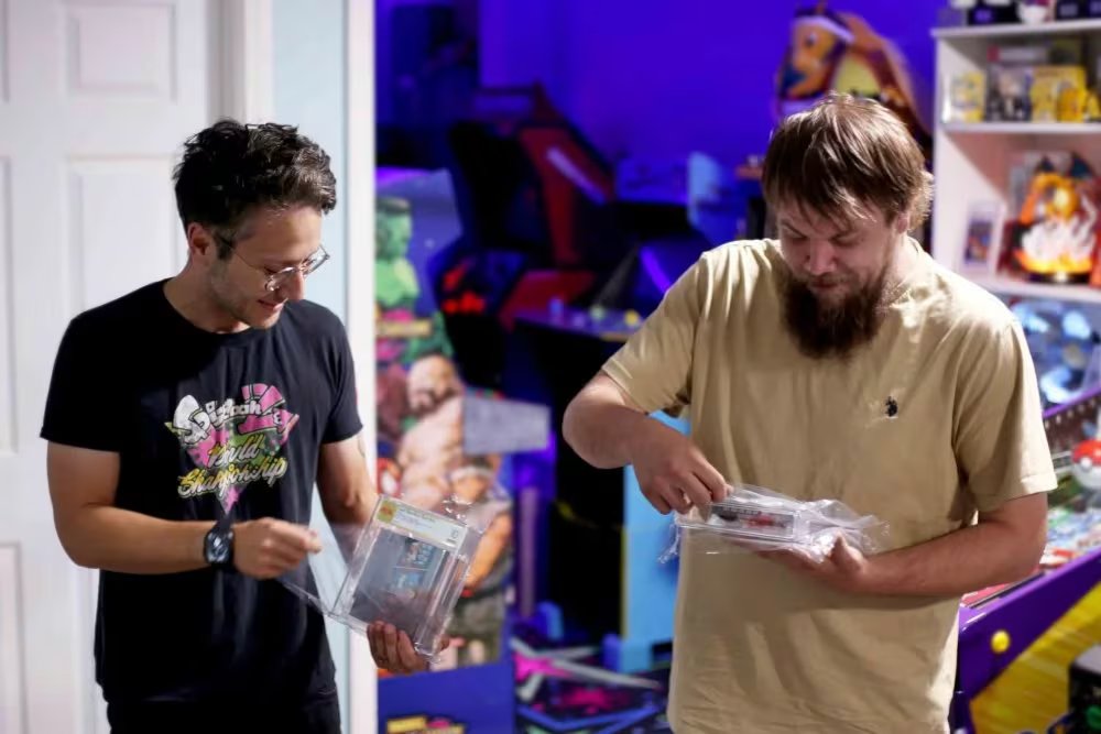 En esta foto proporcionada por Nintendo Wire, el editor Jason Ganos (izquierda) y el propietario de la tienda OneStopWonders, Kevin Braun, sostienen copias certificadas por PSA de los videojuegos Super Mario Bros. y Duck Hunt (Lauren Ganos/Nintendo Wire vía AP)