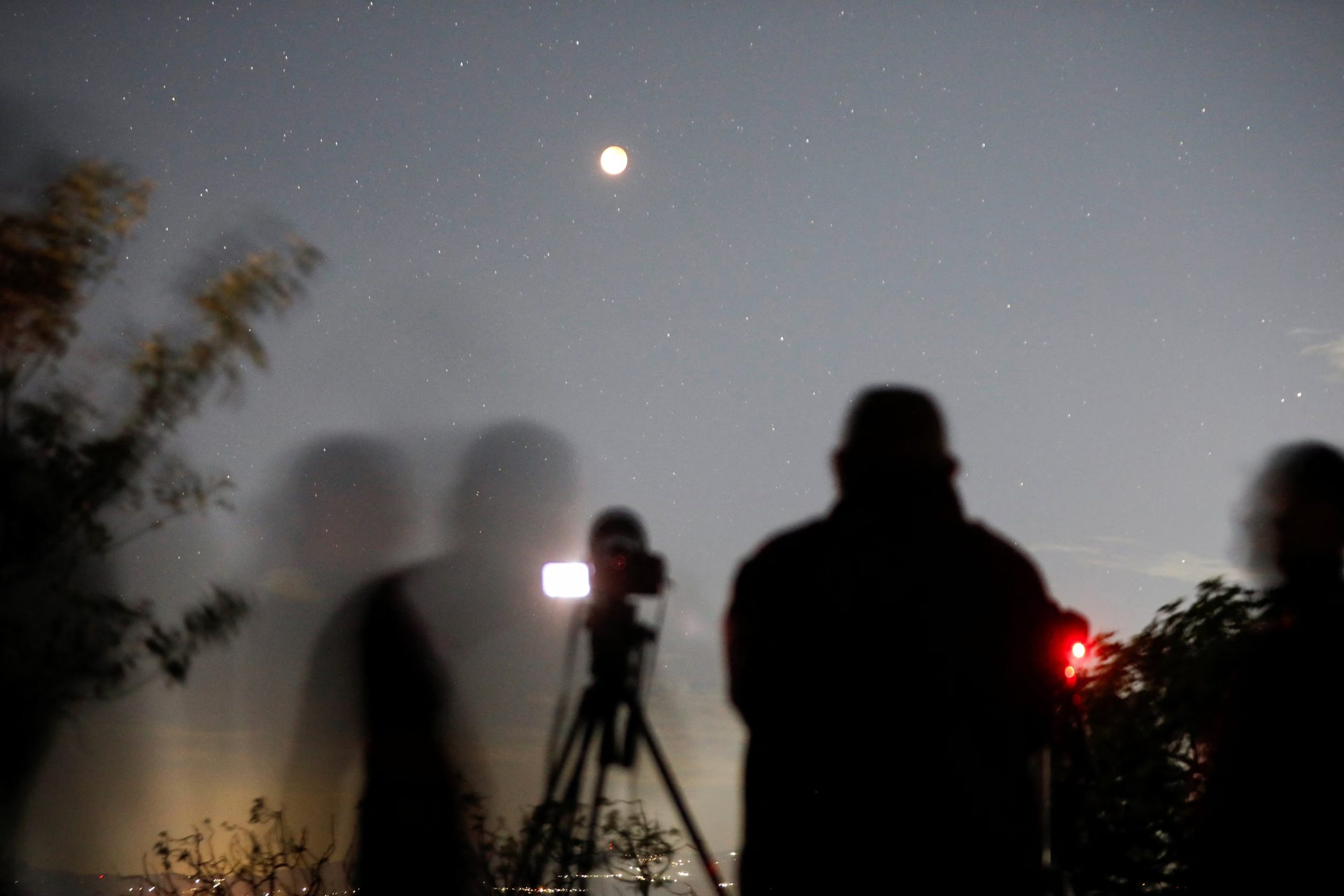 El uso de binoculares o telescopios permite apreciar los relieves de cráteres y los matices cobrizos en el área sombreada durante el eclipse - REUTERS/Jose Cabezas