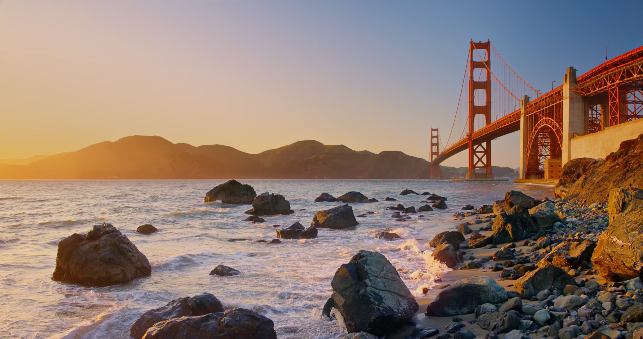 La fotografía muestra una vista panorámica del famoso puente Golden Gate en San Francisco, California, capturado desde la orilla rocosa de Marshall's Beach al atardecer. 

(Difusión) 