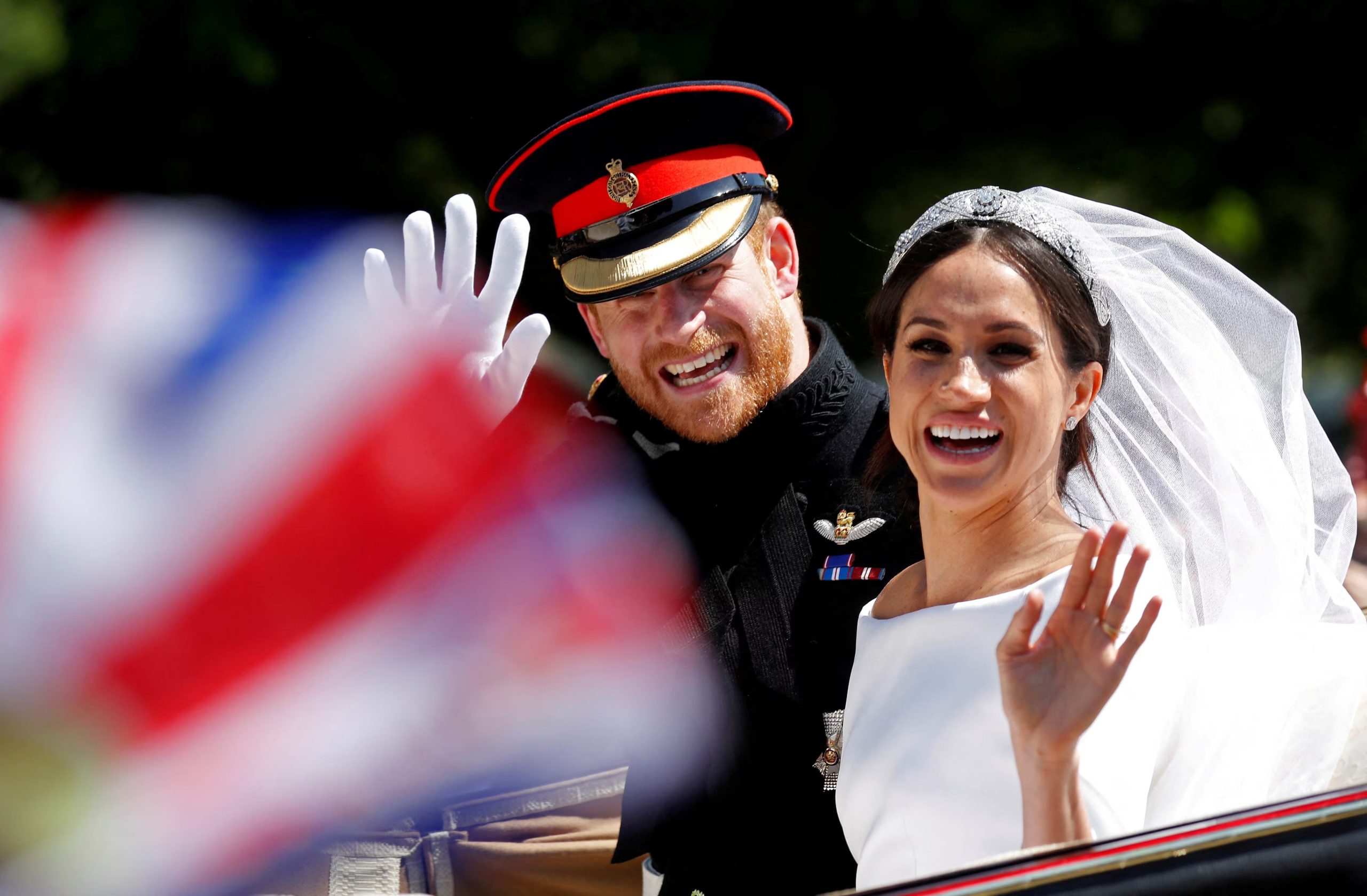 FILE PHOTO: Britain's Prince Harry and his wife Meghan wave as they ride a horse-drawn carriage after their wedding ceremony at St George's Chapel in Windsor Castle in Windsor, Britain, May 19, 2018. REUTERS/Damir Sagolj/File Photo