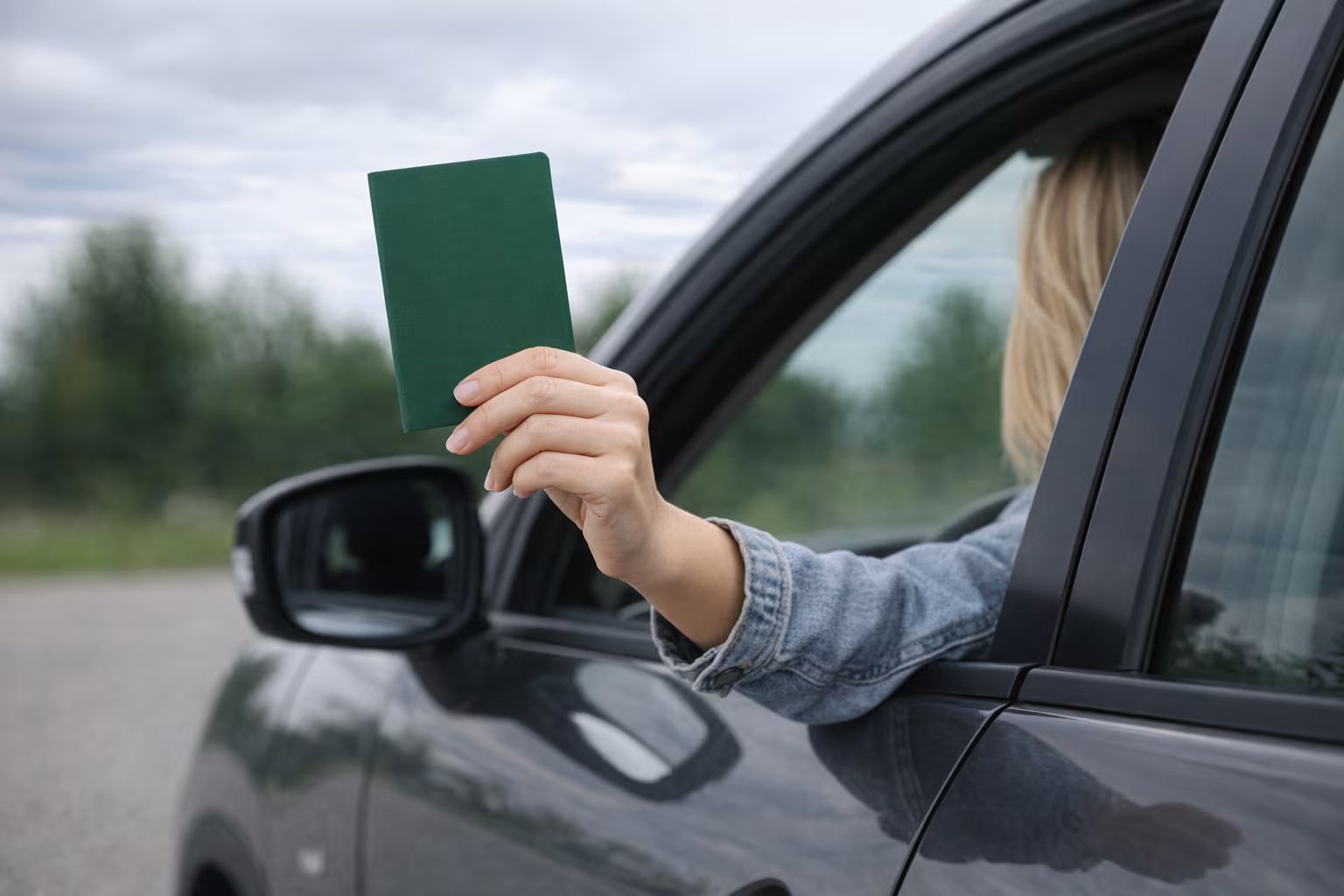Una mujer muestra un pasaporte por la ventanilla del coche. (Imagen Ilustrativa Infobae)