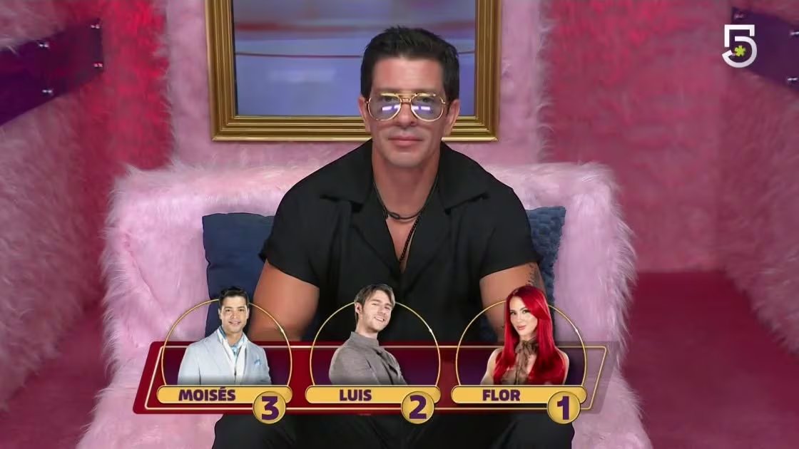 Yahir aparece en un estudio de televisión y presenta la nominación de Moisés, Luis y Flor, cuyos retratos con números se muestran en pantalla. (Facebook: La Casa de los Famosos México4)