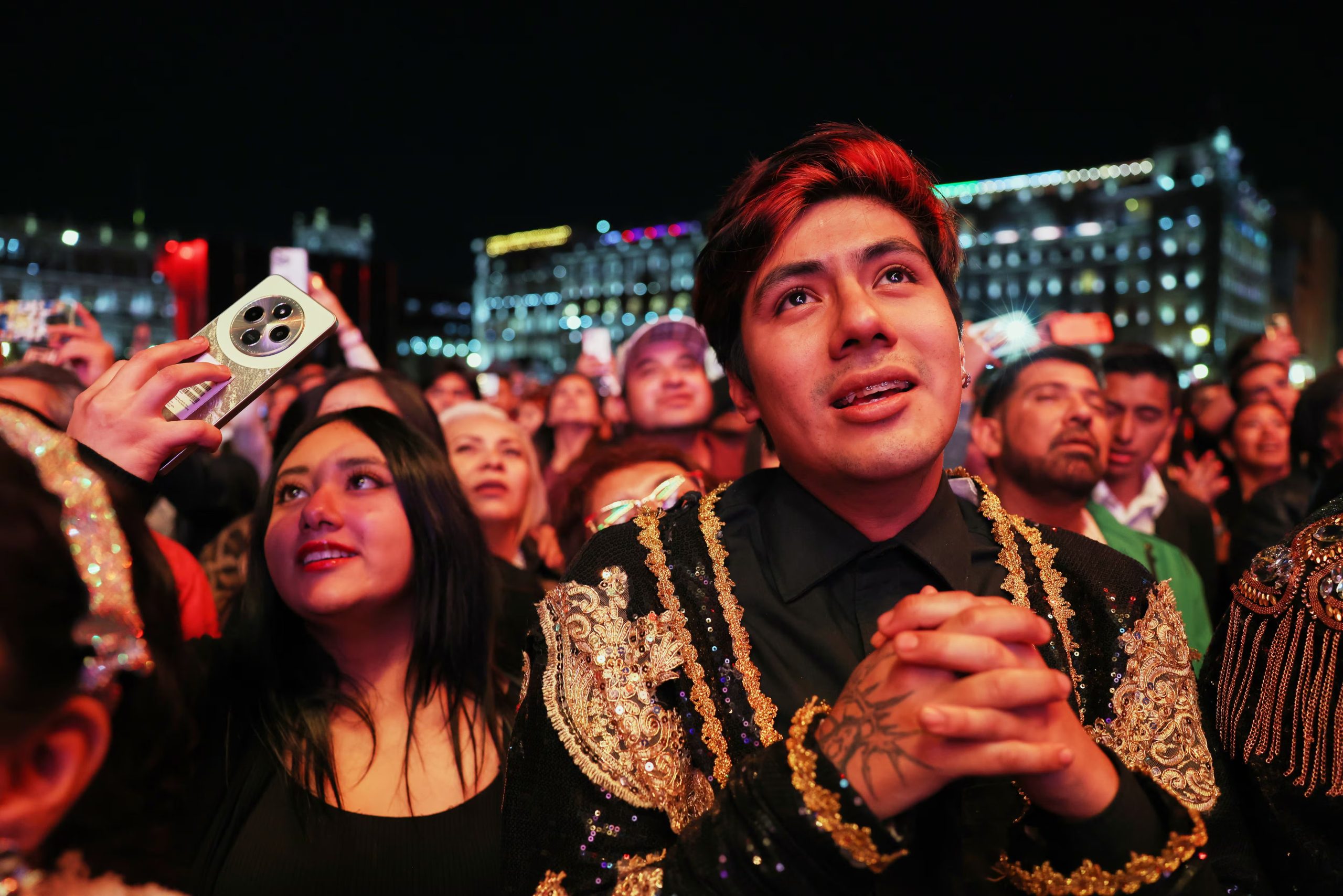 El público disfruta de una proyección gratuita del concierto que el fallecido cantante mexicano Juan Gabriel ofreció en 1990 en Bellas Artes, en el Zócalo, la plaza principal de la Ciudad de México, el sábado 8 de noviembre de 2025. (Foto AP/Claudia Rosel)