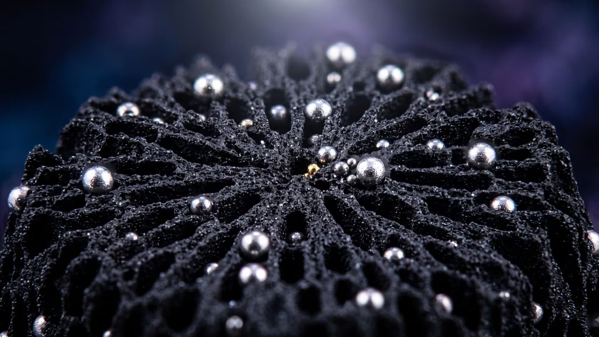 Una superficie de carbono porosa con canales radiales presenta nanopartículas metálicas de platino-cobalto en un entorno microscópico con fondo oscuro. (Imagen Ilustrativa Infobae)