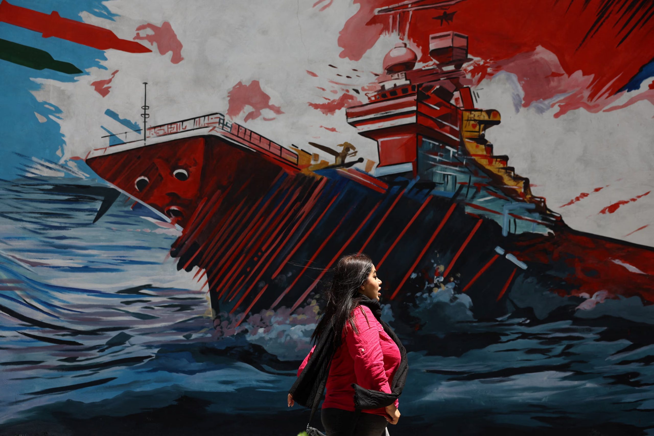 Una mujer camina junto a un mural en una calle de Teherán, el 6 de mayo, en medio de la tensión entre Irán y Estados Unidos por el bloqueo del estrecho de Ormuz (REUTERS/Majid Asgaripour/WANA)