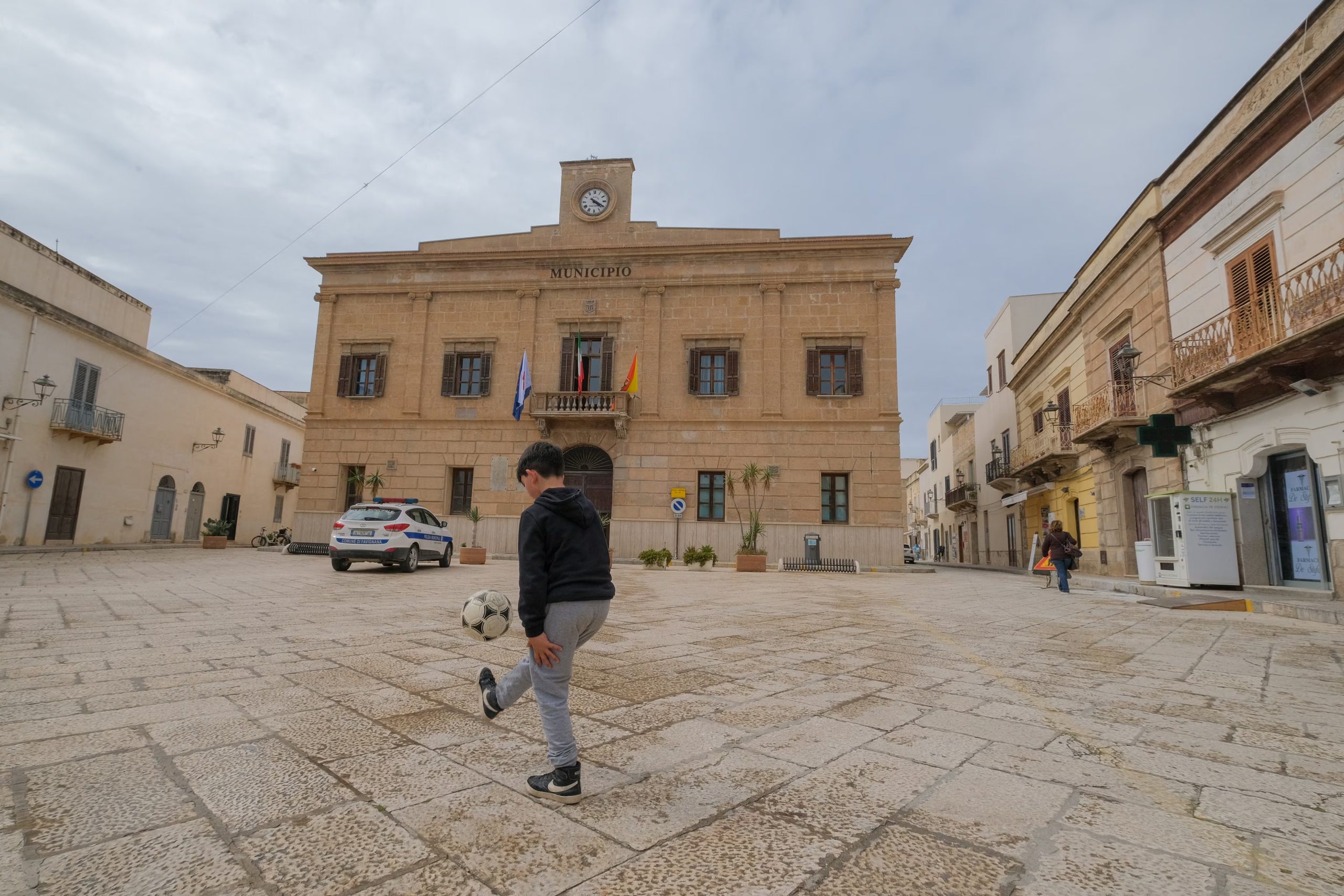 Un niño juega al fútbol frente al ayuntamiento de Favignana, uno de los lugares de rodaje de