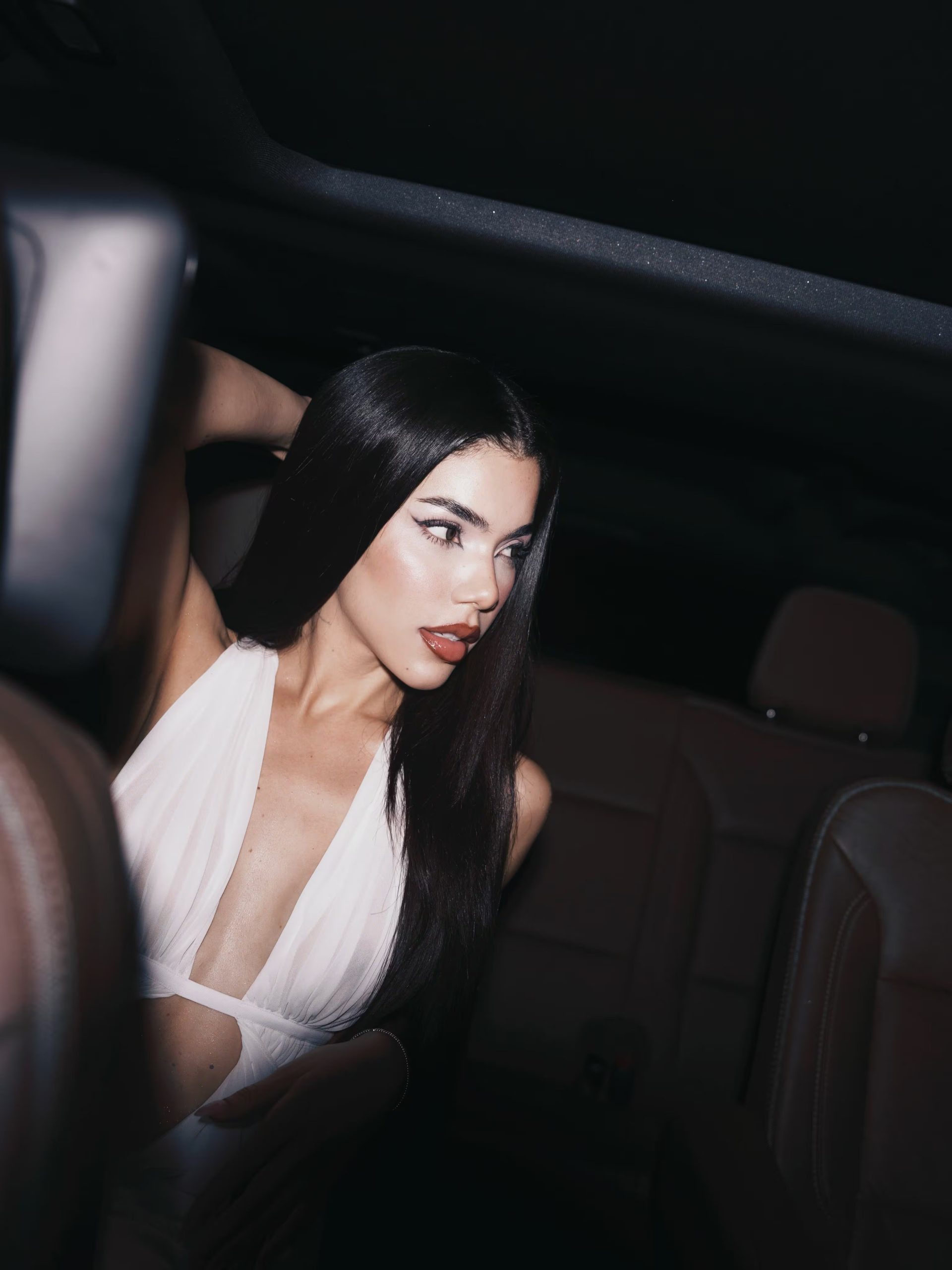 Una mujer posa con un vestido blanco de novia en el interior de un automóvil. (Kenia Os/Instagram)