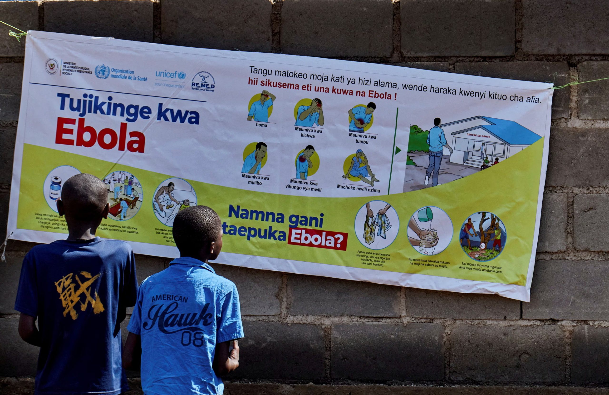 Niños congoleños leen un cartel informativo mientras las agencias de ayuda intensifican sus esfuerzos para contener un nuevo brote de ébola relacionado con la cepa Bundibugyo, en Bunia, provincia de Ituri, República Democrática del Congo (REUTERS/Gradel Muyisa Mumbere)