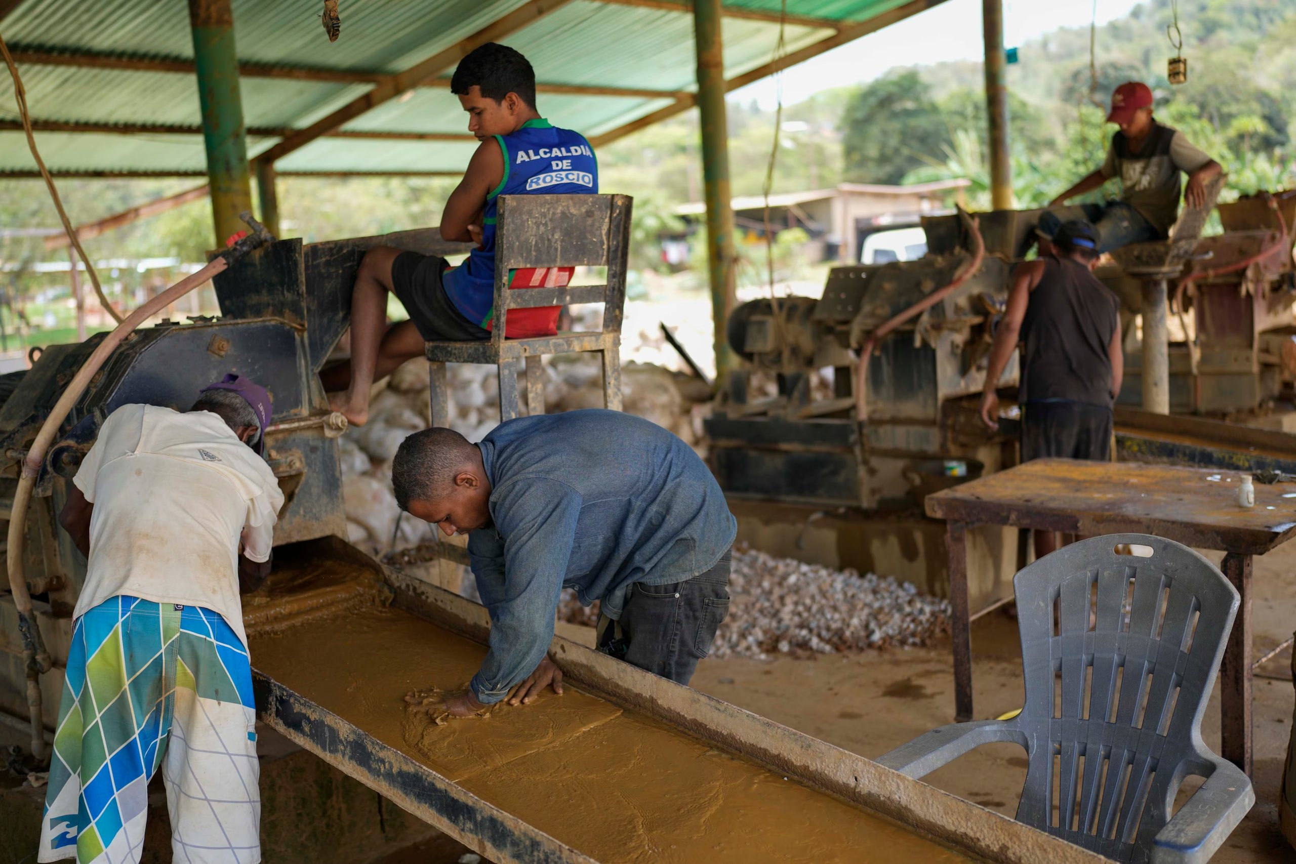Los trabajadores echan arena de las piedras molidas sobre placas de cobre que atrapan las partículas de oro en la mina de El Callao, estado Bolívar, Venezuela, 28 de abril de 2023. Venezuela es famosa por poseer las reservas de petróleo más grandes del mundo, pero su suelo también tiene otro recurso valioso: oro, el cual ha dado pie a una amplia minería en la que los trabajadores enfrentan severas condiciones.(AP Foto/Matias Delacroix)