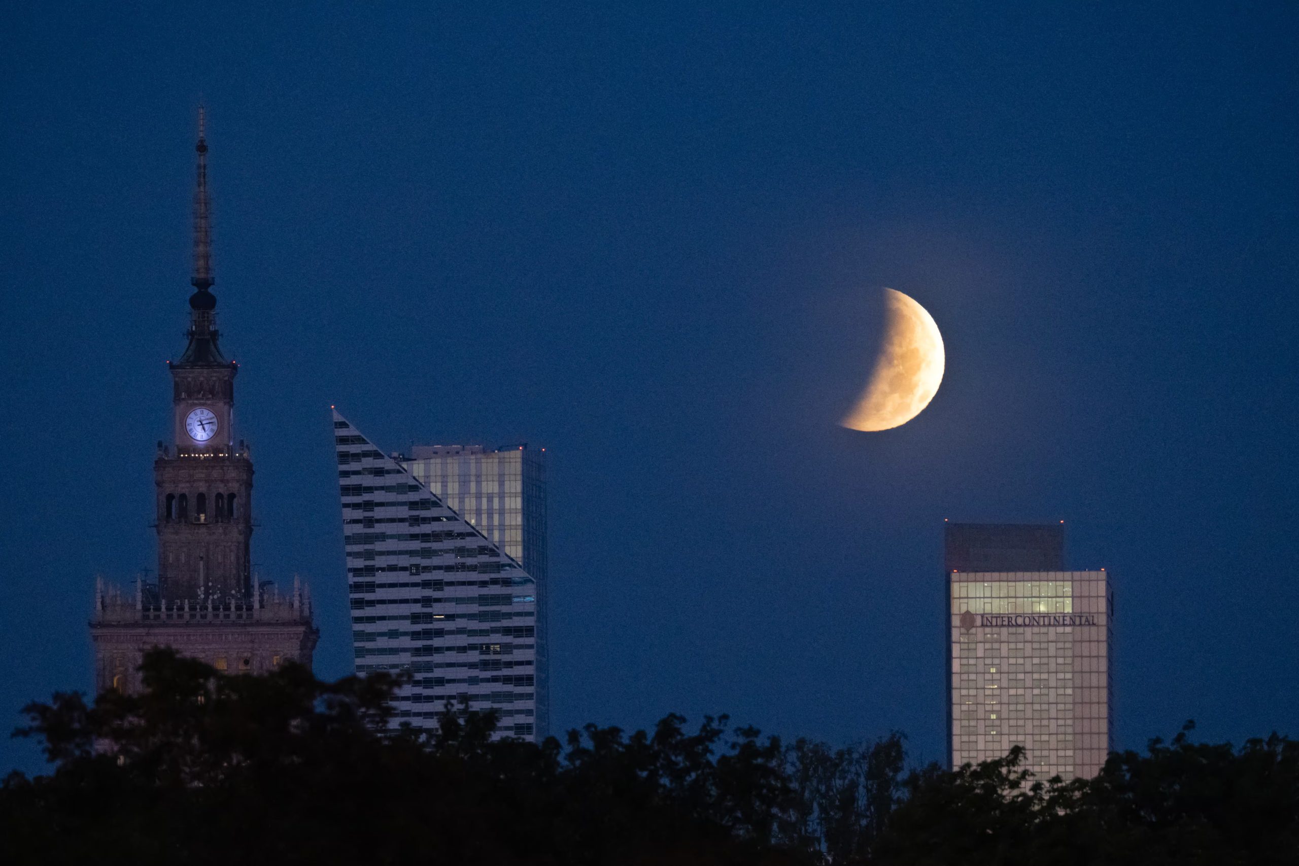 La luna llena, también conocida como la Luna del Esturión, se ocultó tras los rascacielos de Varsovia durante un eclipse lunar parcial, el 28 de agosto de 2026 (Sergei Gapon/AFP)