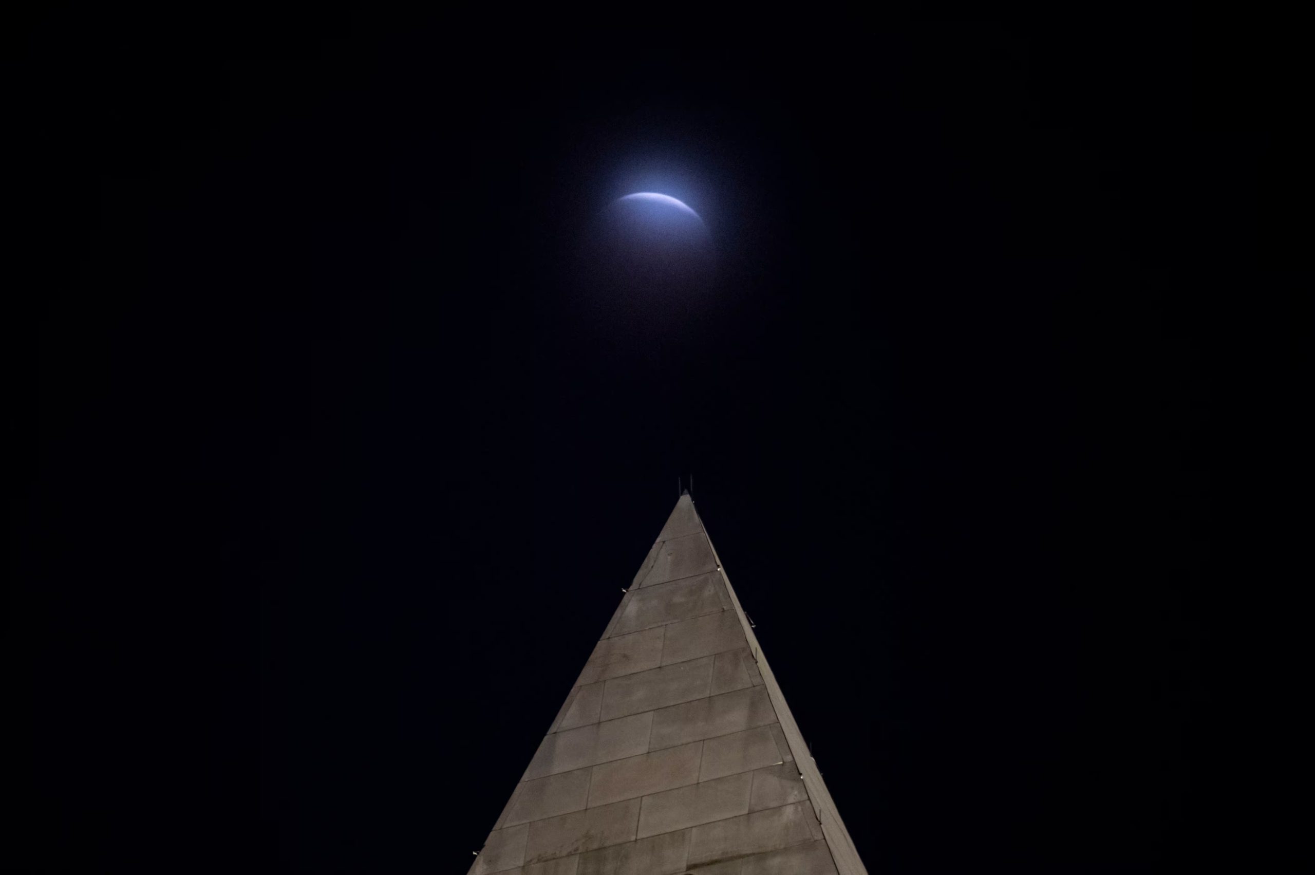 Se observa un eclipse lunar a través de las nubes, detrás del Monumento a Washington, en Washington, el viernes 28 de agosto de 2026 (AP/Cliff Owen)