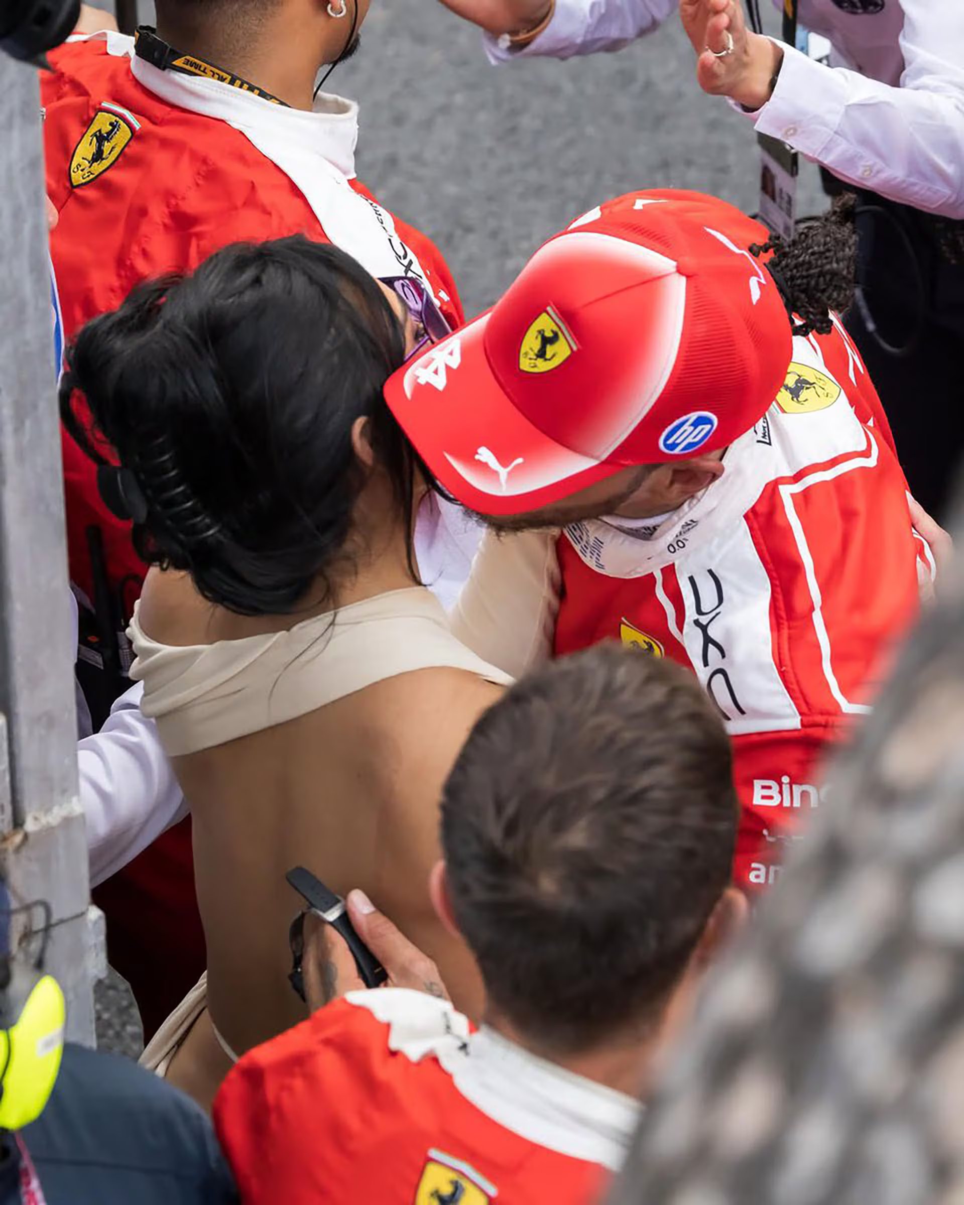 Lewis Hamilton, vestido con un traje de Ferrari, comparte un momento cercano con Kim Kardashian en una aparición pública en Mónaco.