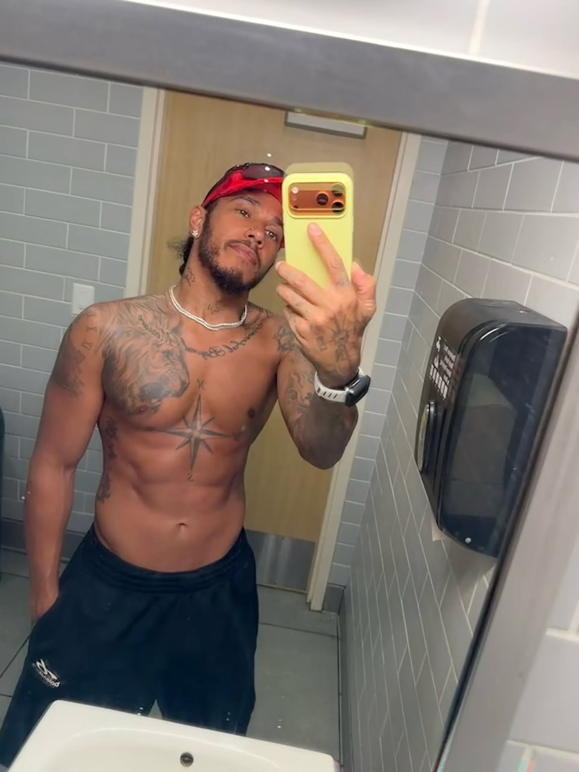 El piloto Lewis Hamilton se retrata sin camiseta frente a un espejo, mostrando sus tatuajes en una imagen capturada durante sus vacaciones