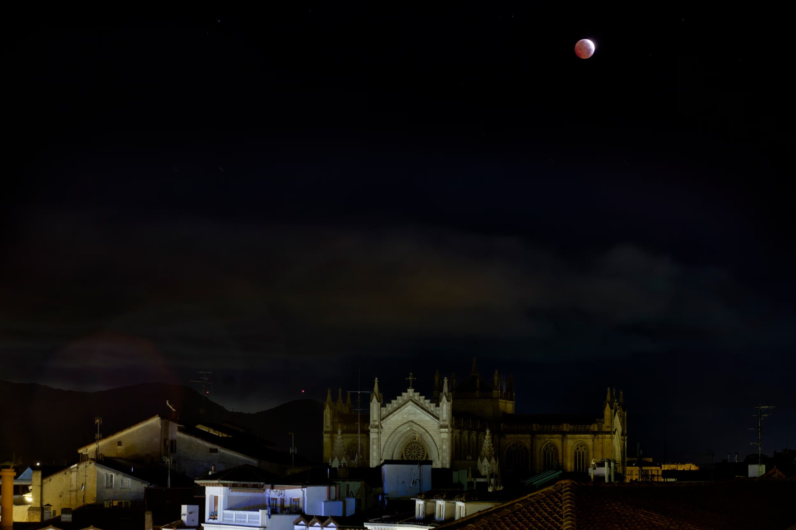 Fase máxima del eclipse lunar parcial, este viernes, visto sobre la Catedral de Santa María Inmaculada de la capital vasca de Vitoria-Gasteiz. (EFE/Adrián Ruiz Hierro)
