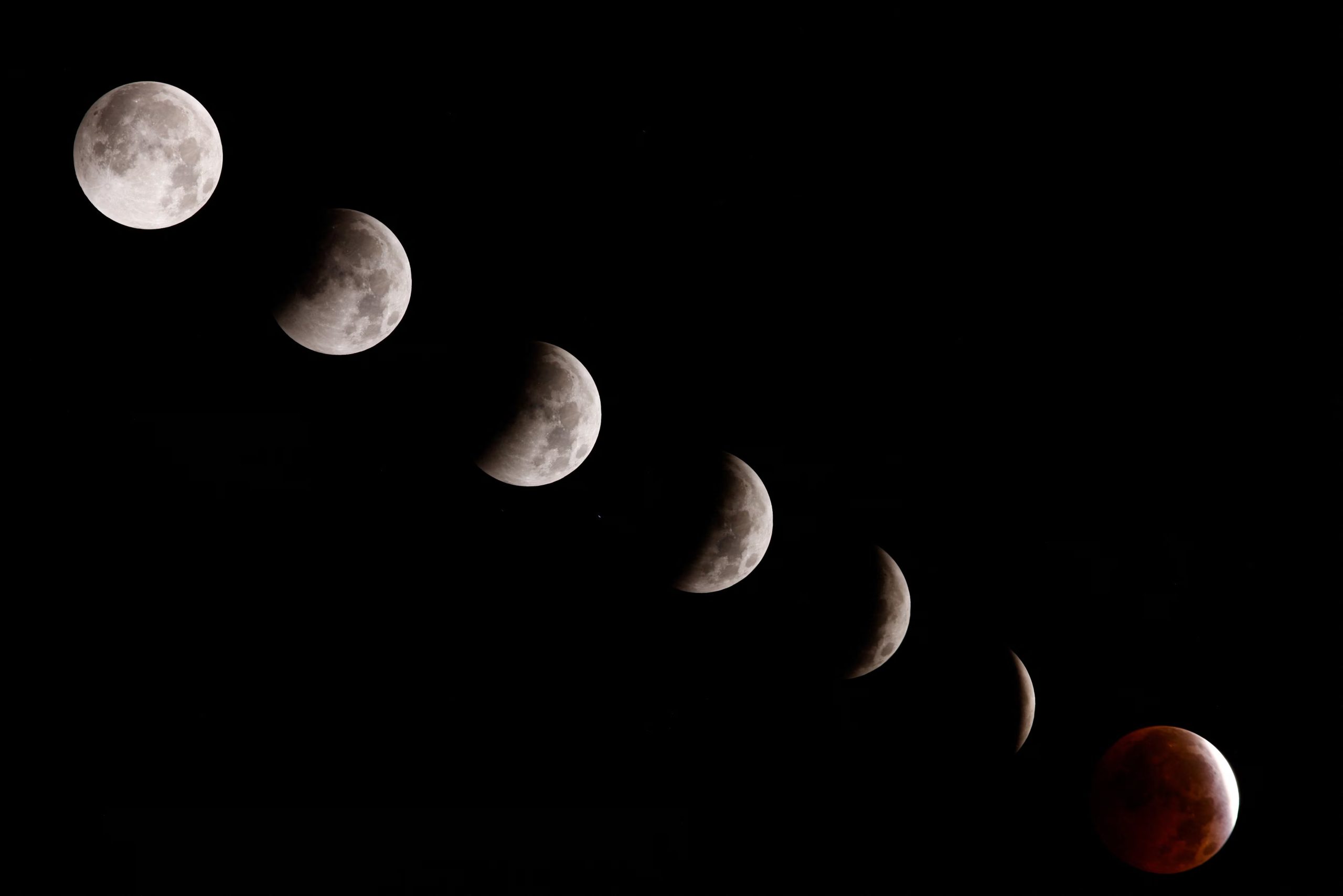 A composite image of seven separate photographs taken with a single fixed camera shows stages of a partial lunar eclipse over Pico De Las Nieves on the island of Gran Canaria, Spain, August 28, 2026. REUTERS/Borja Suarez