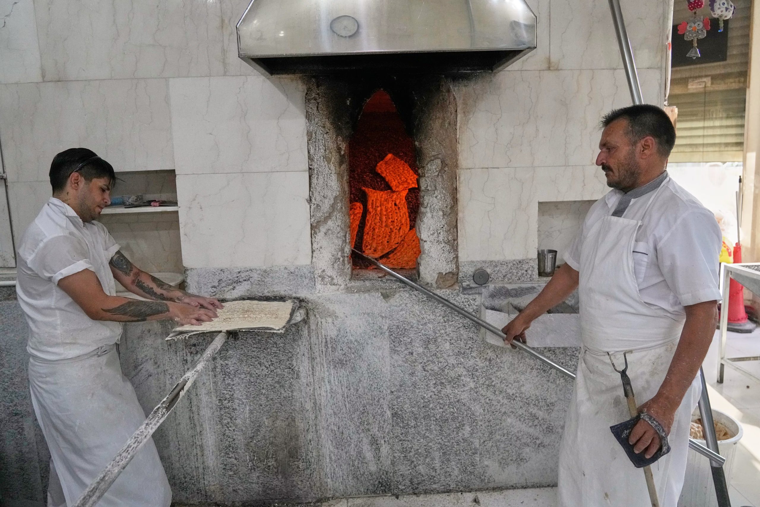 Trabajadores preparan sangak, un pan plano tradicional iraní, en una panadería en Teherán, Irán, el martes 18 de agosto de 2026. (Foto AP/Vahid Salemi)

