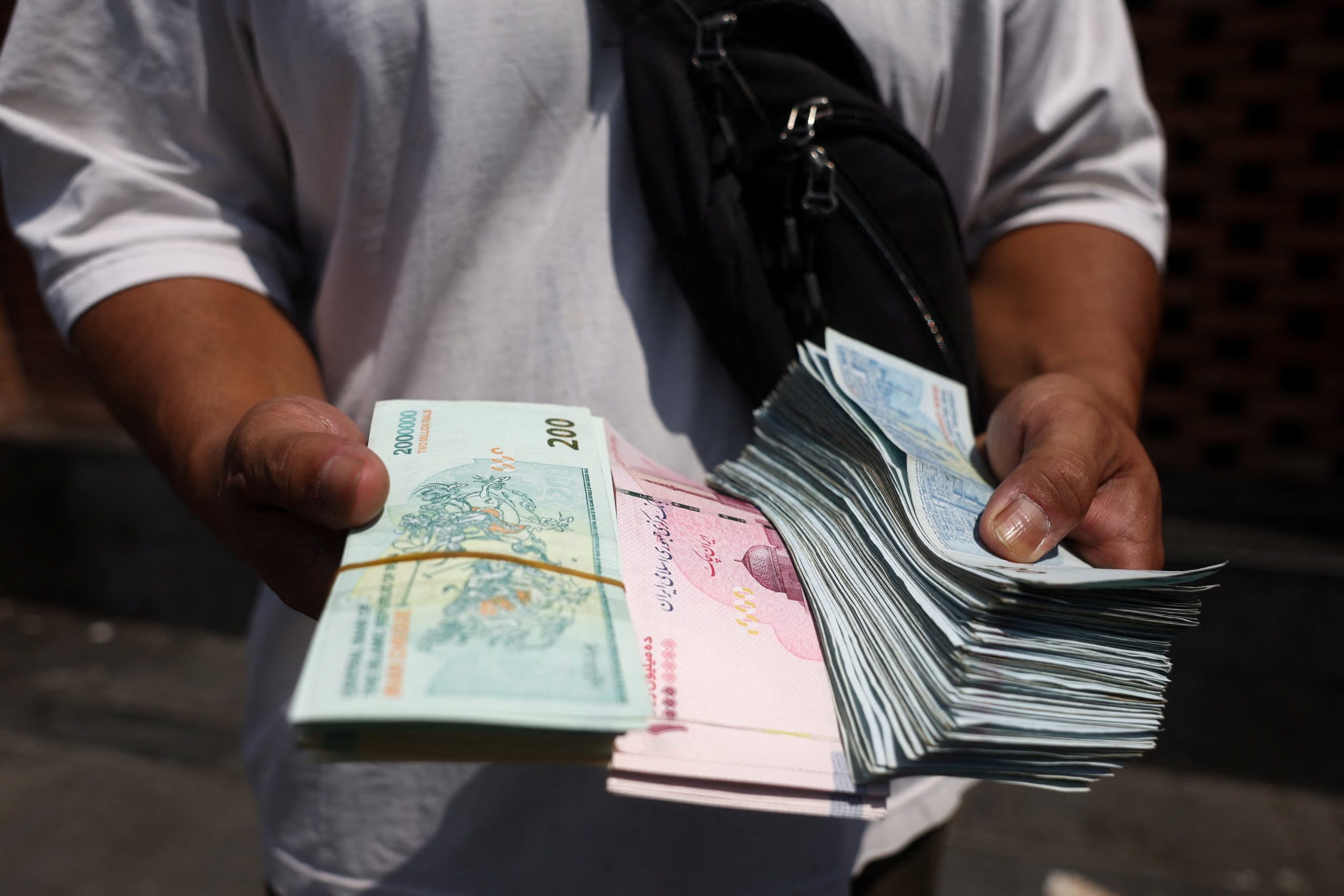 Un cambista sostiene riales iraníes en el Gran Bazar de Teherán (Majid Asgaripour/WANA (West Asia News Agency) vía REUTERS/Archivo)
