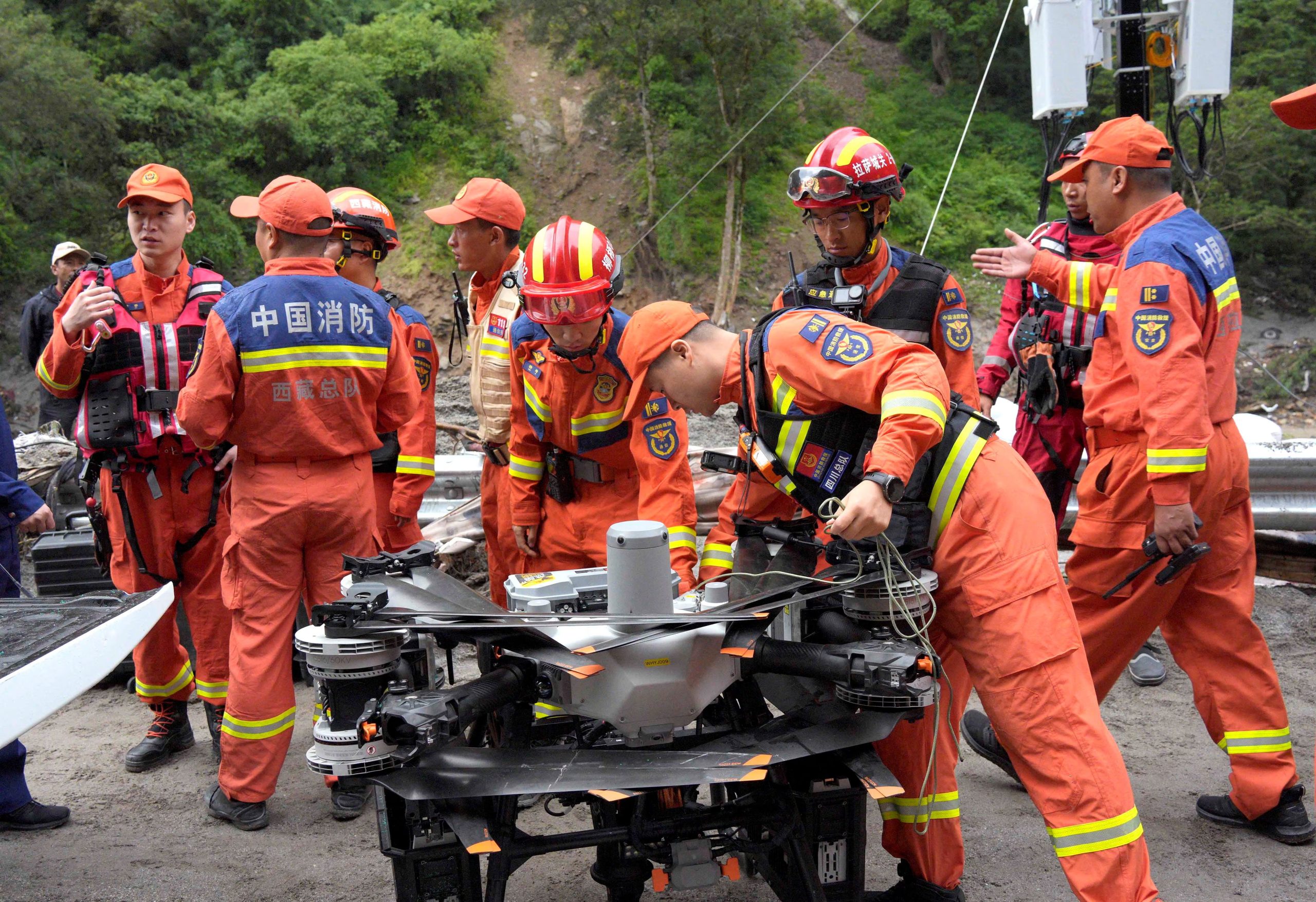 Bomberos se reúnen cerca de un dron durante las operaciones de rescate tras un deslizamiento de tierra en el condado de Gyirong, Shigatse, Región Autónoma del Tíbet, China, el 28 de agosto de 2026 (cnsphoto vía REUTERS)