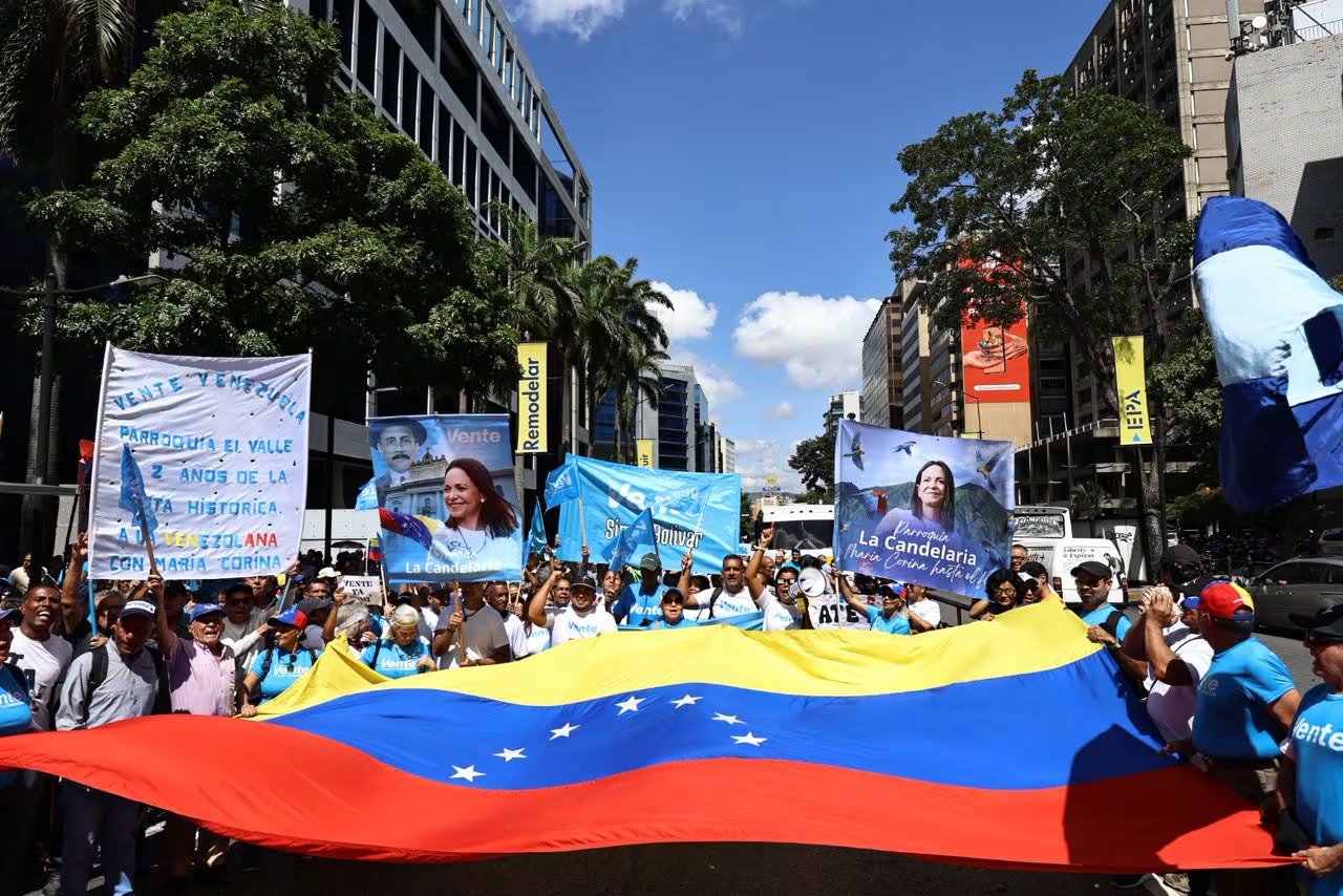 Cientos de personas con banderas y pancartas marchan en una calle de Caracas para demandar elecciones libres y la habilitación de María Corina Machado. (@VenteVenezuela)