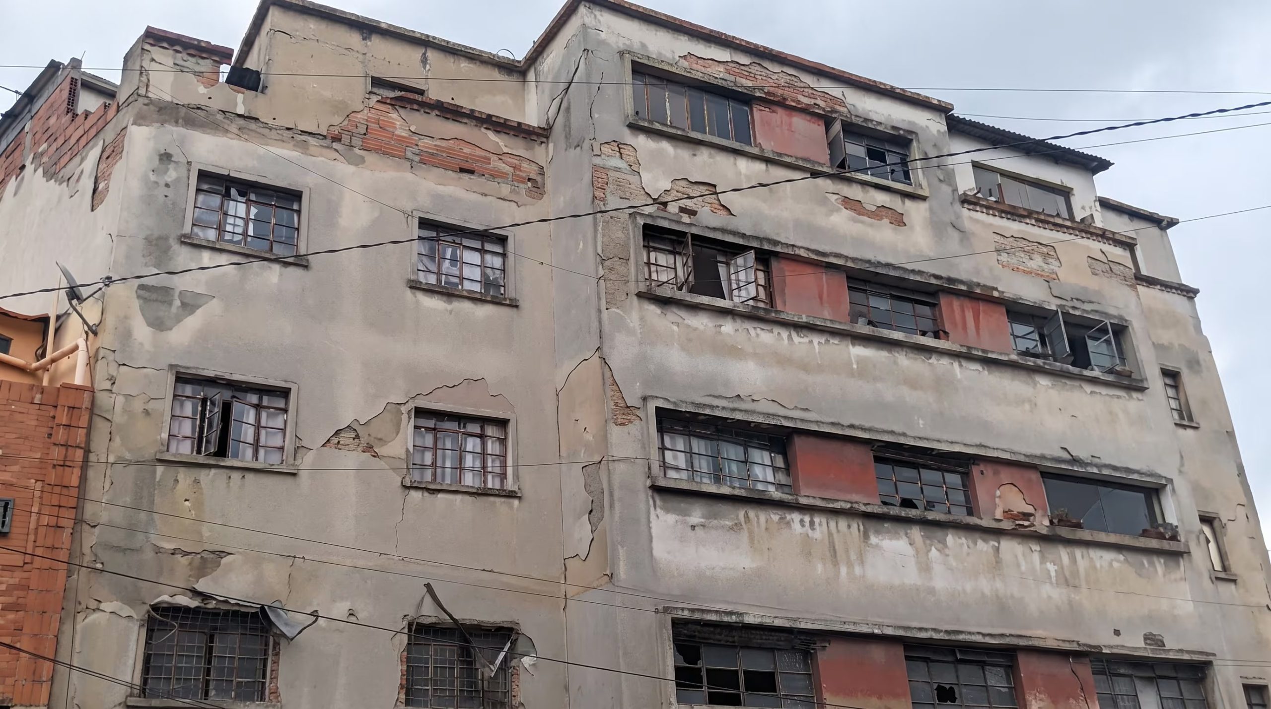 Un edificio de múltiples plantas muestra graves daños en su fachada, con el yeso desprendido y varias ventanas rotas, lo que es indicativo de un fuerte movimiento sísmico. (Agencia Andina)