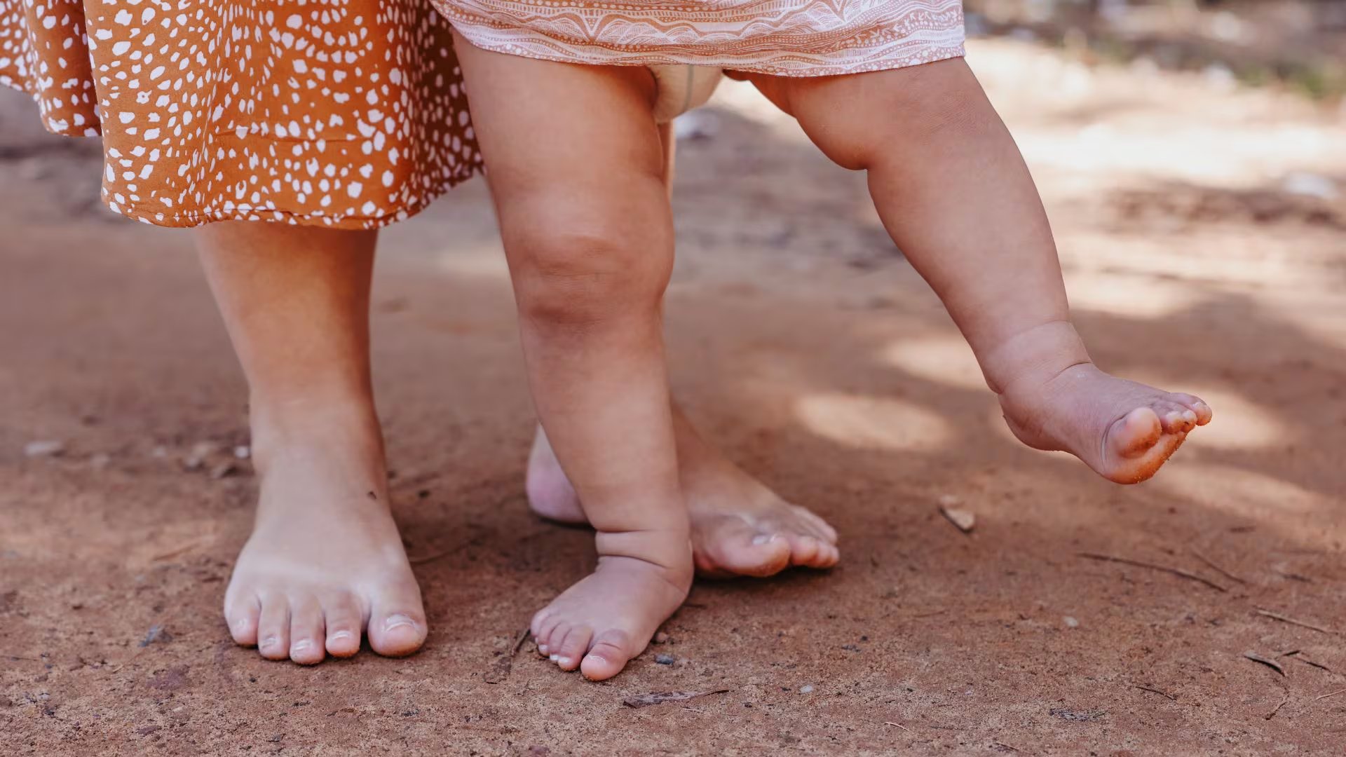 Una madre con su bebé recién nacido aprendiendo a andar (Canva)