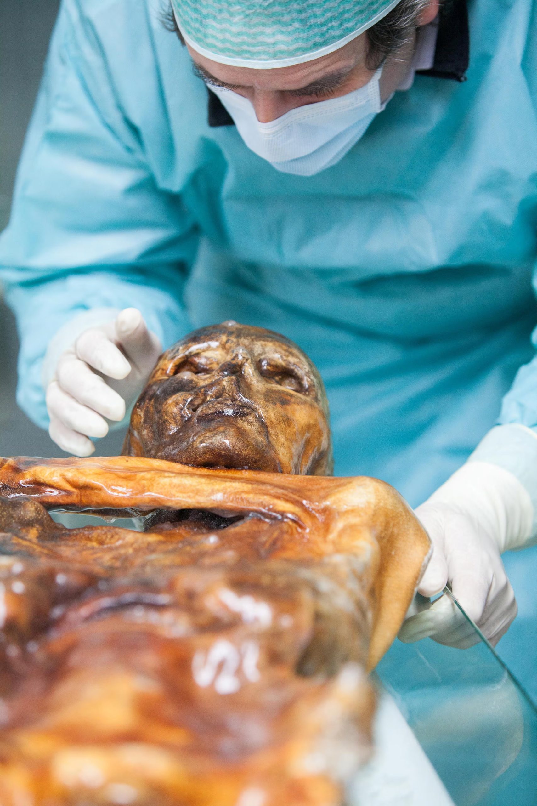 Un investigador examina los restos momificados de Ötzi en una cámara de conservación del Museo de Arqueología del Tirol del Sur en Bolzano, Italia (Museo de Arqueología del Tirol del Sur/Eurac Research/Marion Lafogler/Imagen cedida vía REUTERS)