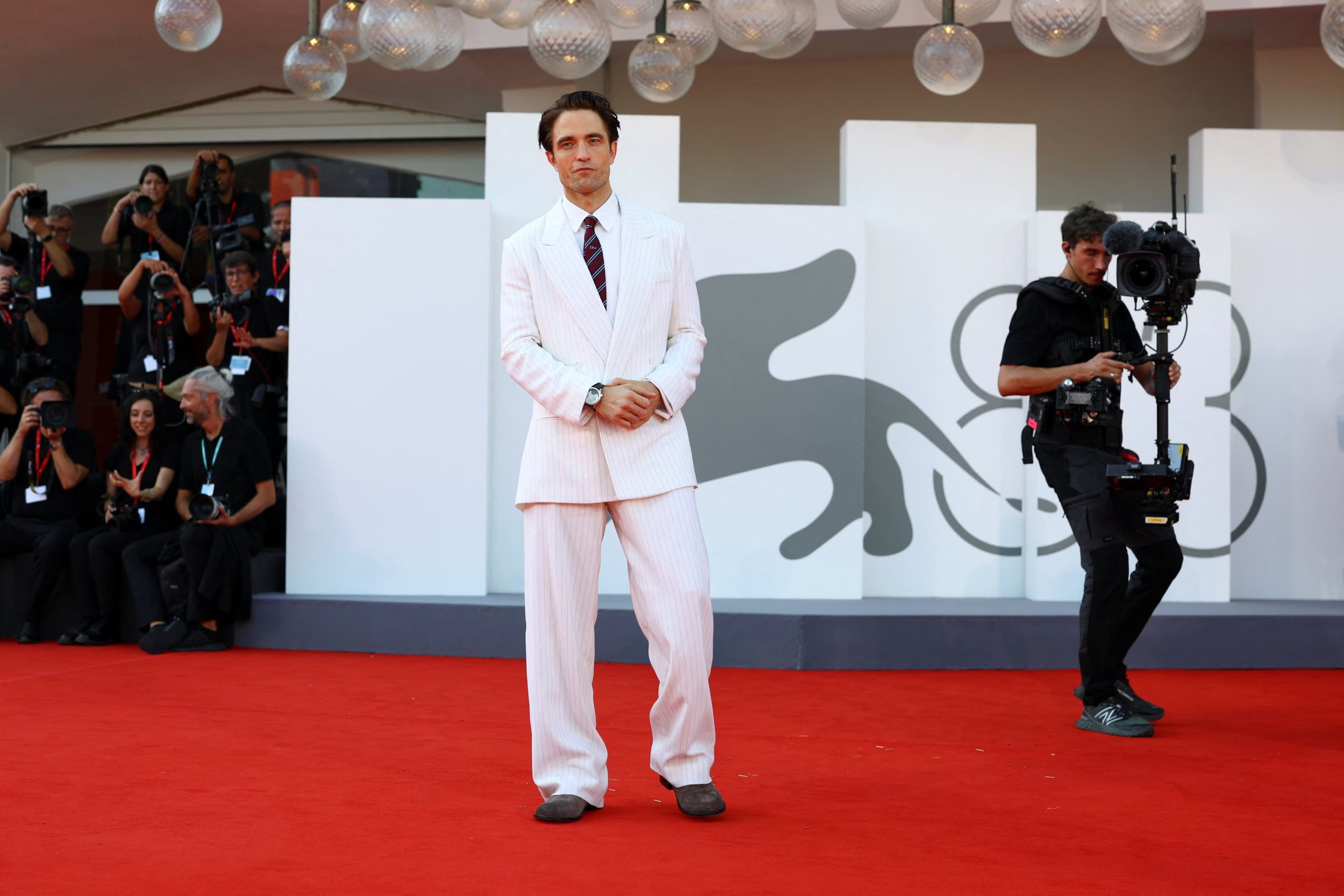 El color rosa pálido renovó el peso visual del traje de Robert Pattinson sin romper con la tradición de la sastrería clásica. (REUTERS/Yves Herman)