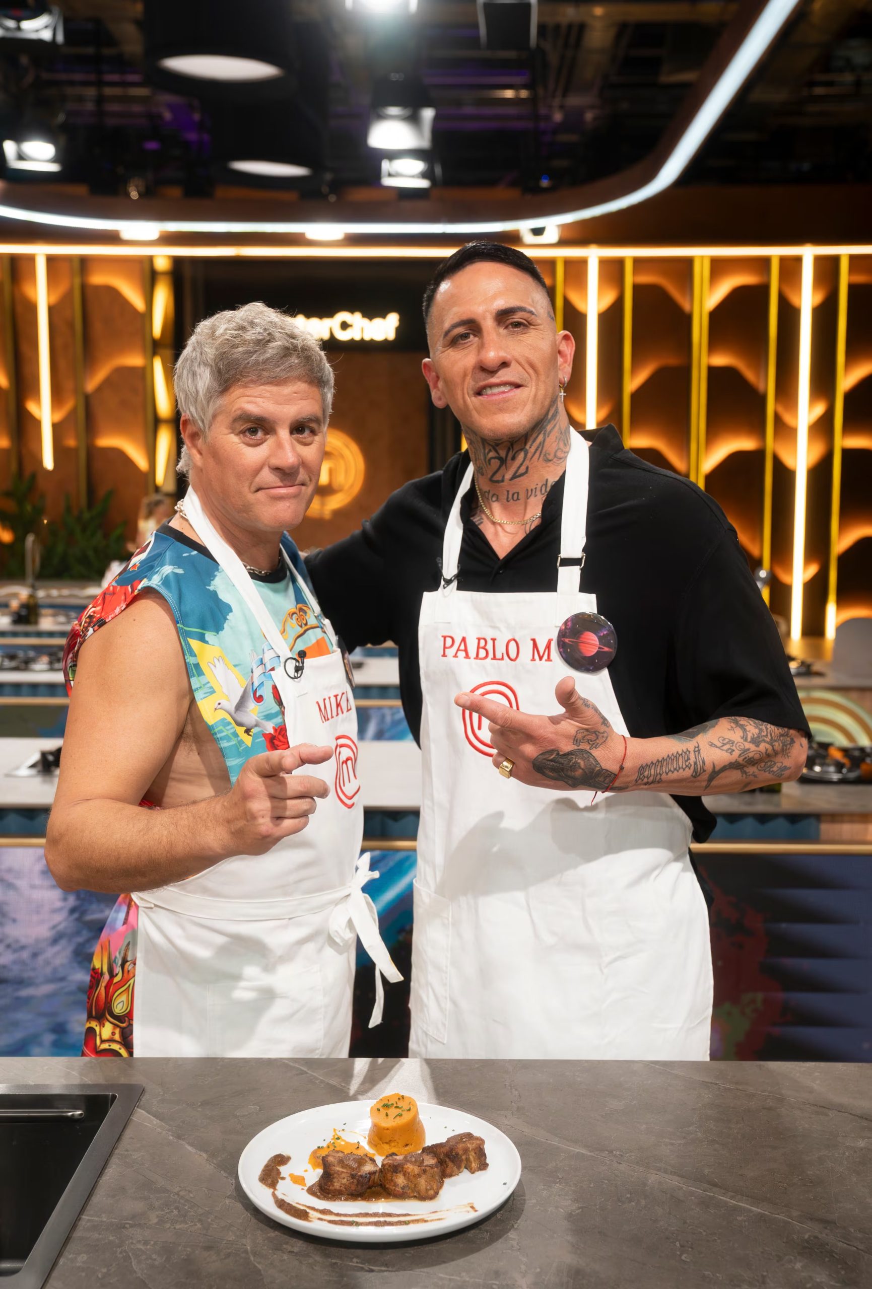 El actor Mike Amigorena y el exfutbolista Pablo Migliore posan junto a su preparación en MasterChef Celebrity