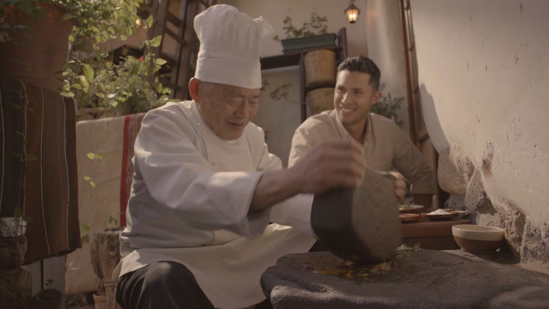 El chef Rodrigo Fernandini observa la molienda de ingredientes en un batán tradicional durante una escena de la película peruana Ceviche.