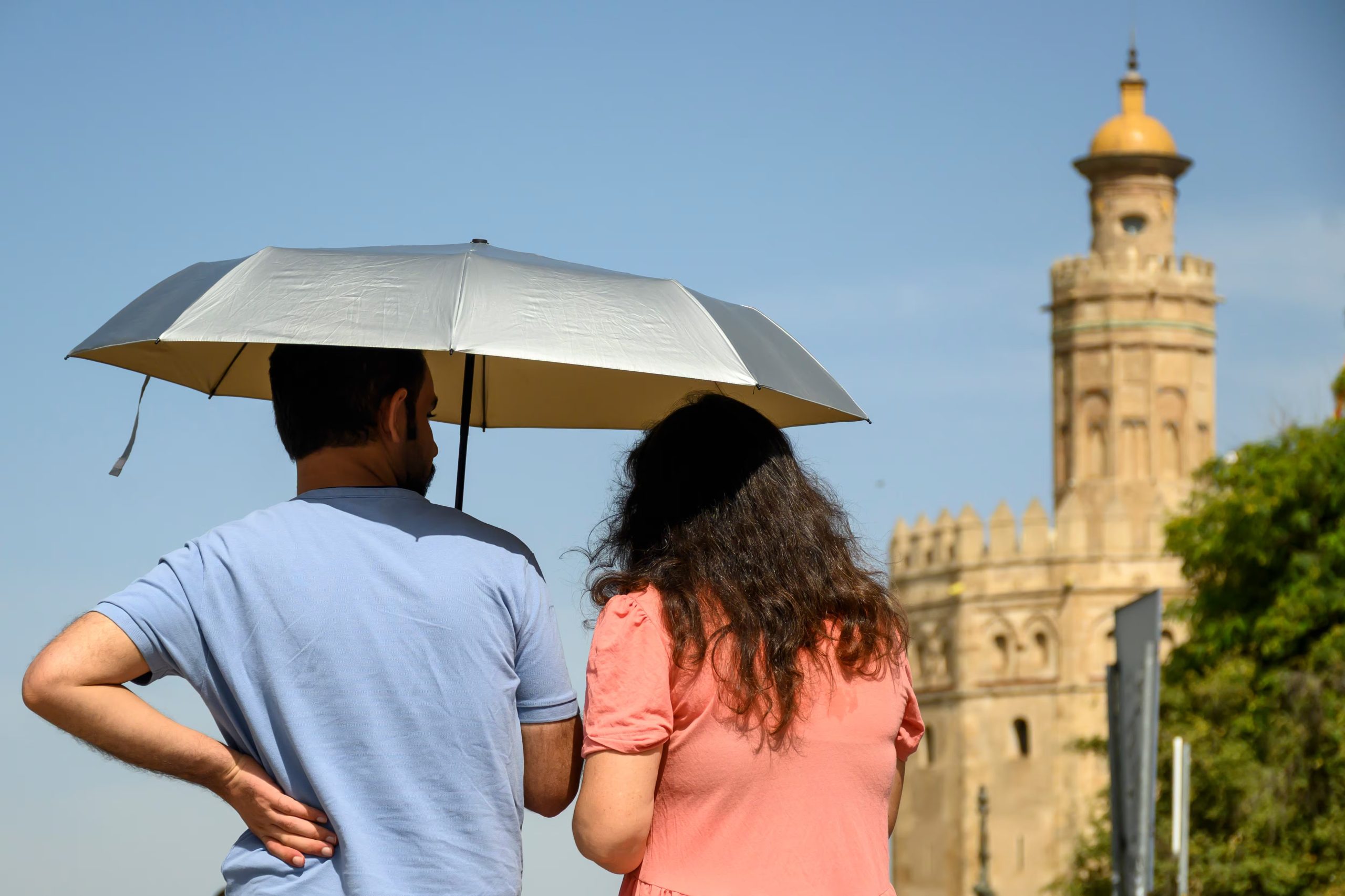 Foto de archivo. Una pareja se resguarda del sol en Sevilla. EFE/Raul Caro
