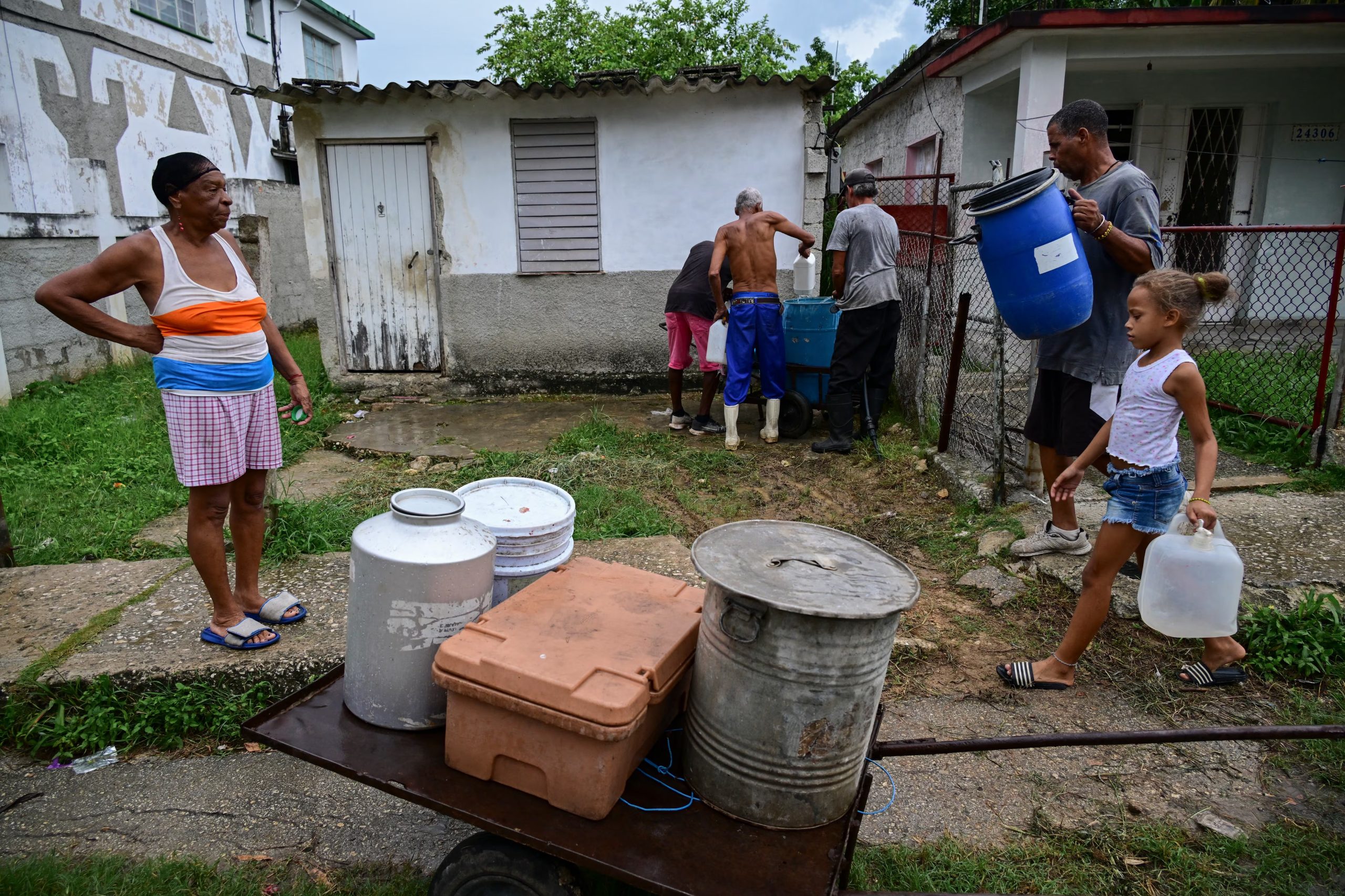 Familias enteras buscan continuamente formas de abastecerse de agua para su consumo diario. (Infobae Cuba/ YAMIL LAGE / AFP)
