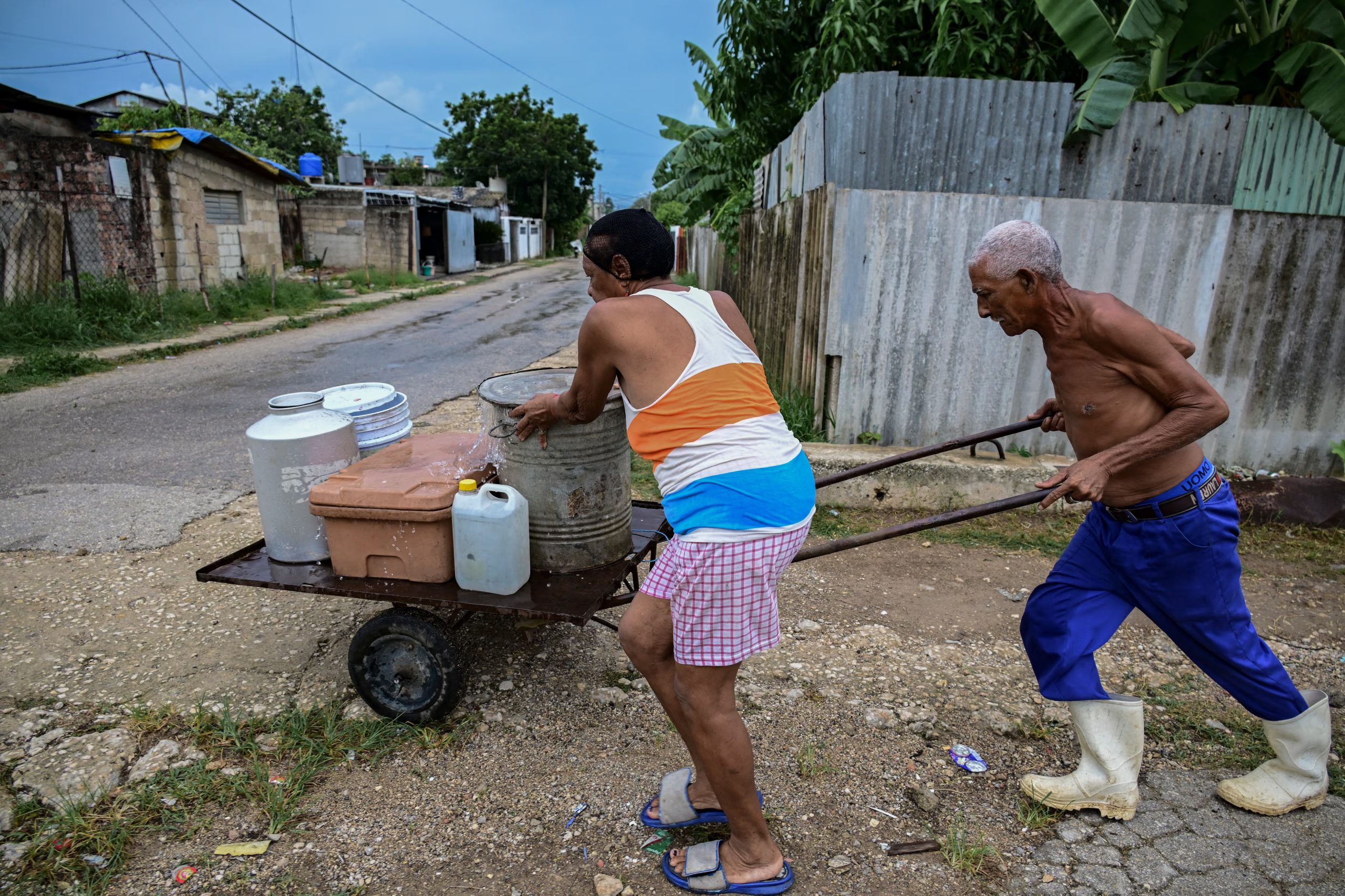 Para quienes tienen menor capacidad económica, la única opción es la fuerza física. Es común ver las calles de cualquier ciudad cubana llenas de personas transportando agua. (Infobae Cuba/ YAMIL LAGE / AFP)